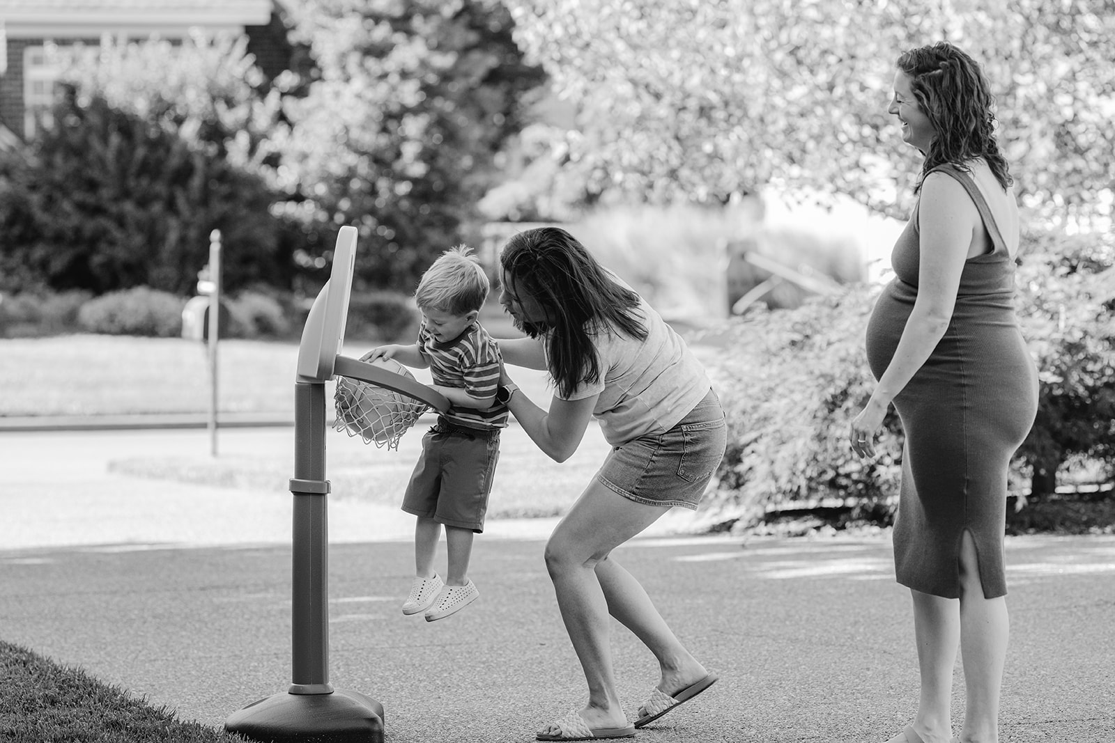 Moms playing basketball with son. LGBTQ Backyard summer family session in Nashville, TN