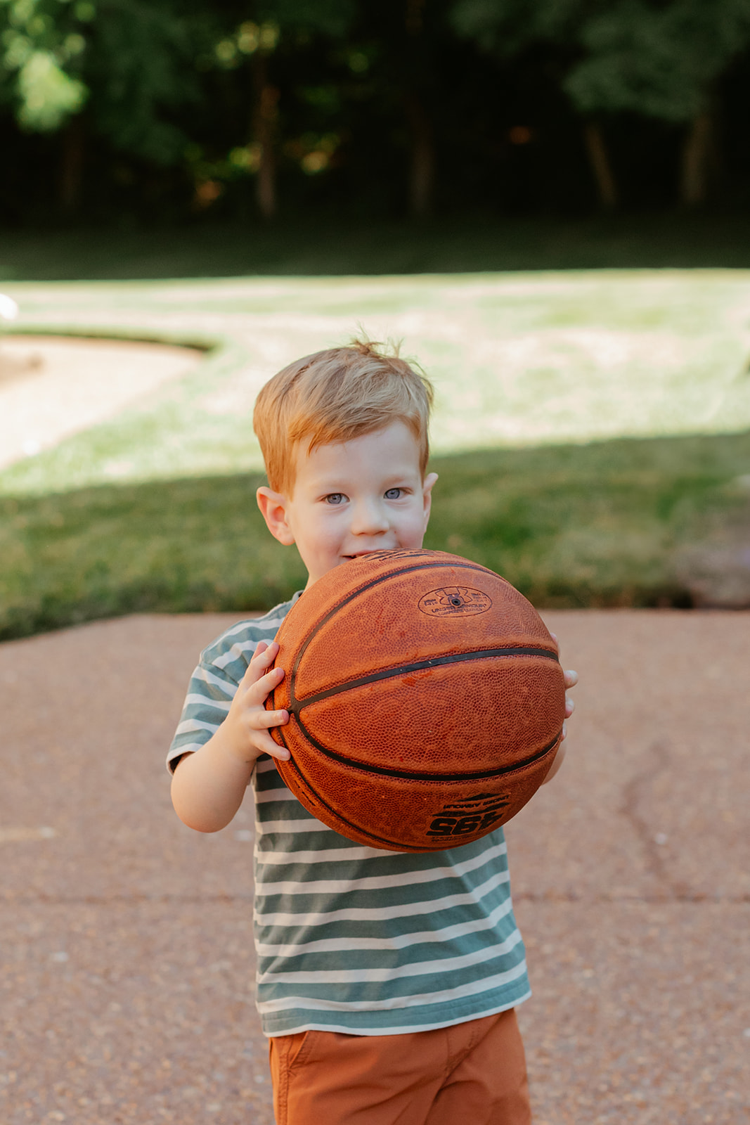 Little boy holding basketball. Backyard summer family session in Nashville, TN