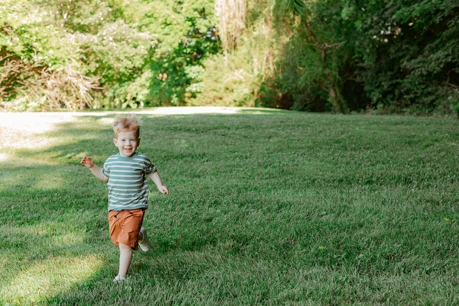 Little boy running in grass. Backyard summer family session in Nashville, TN