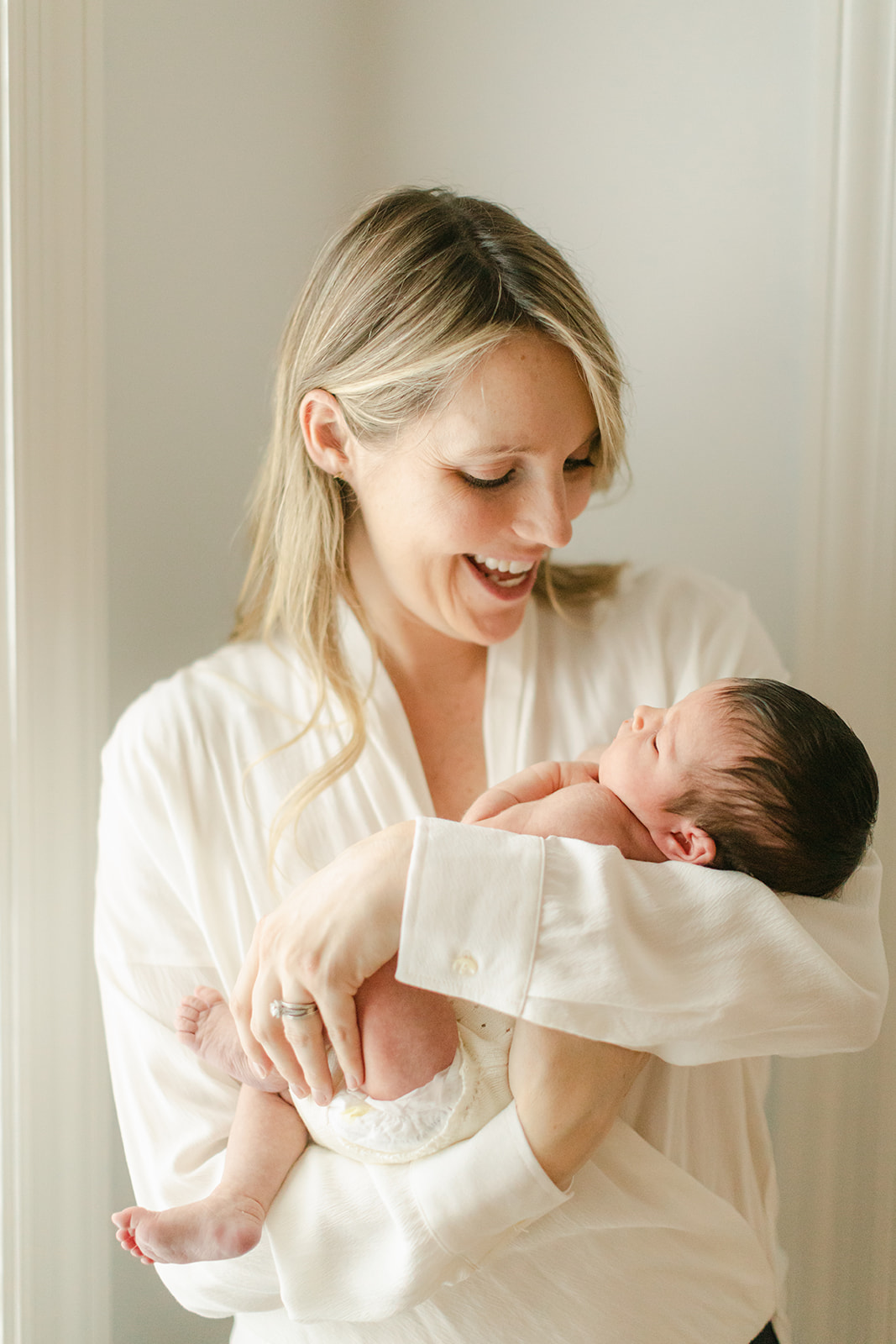 mama in white blouse holding newborn baby