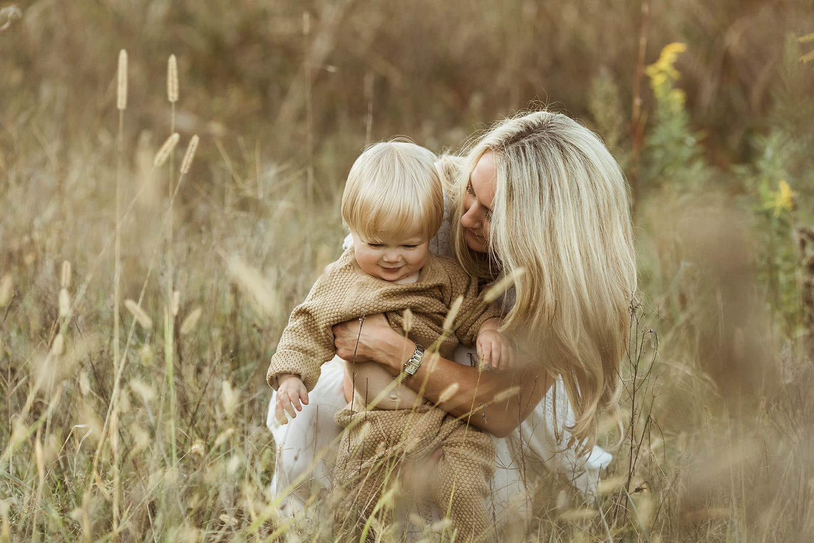 mama and baby boy in open field during fall family photos