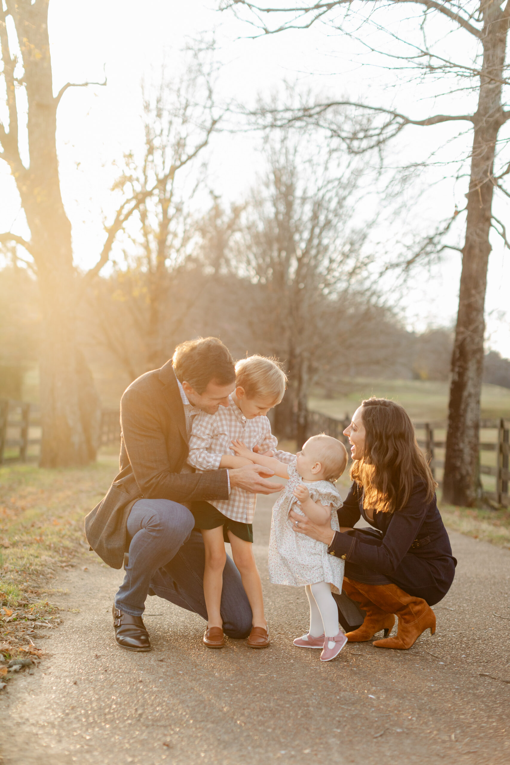 fall family photos in tree filled path. parents with little girl and boy