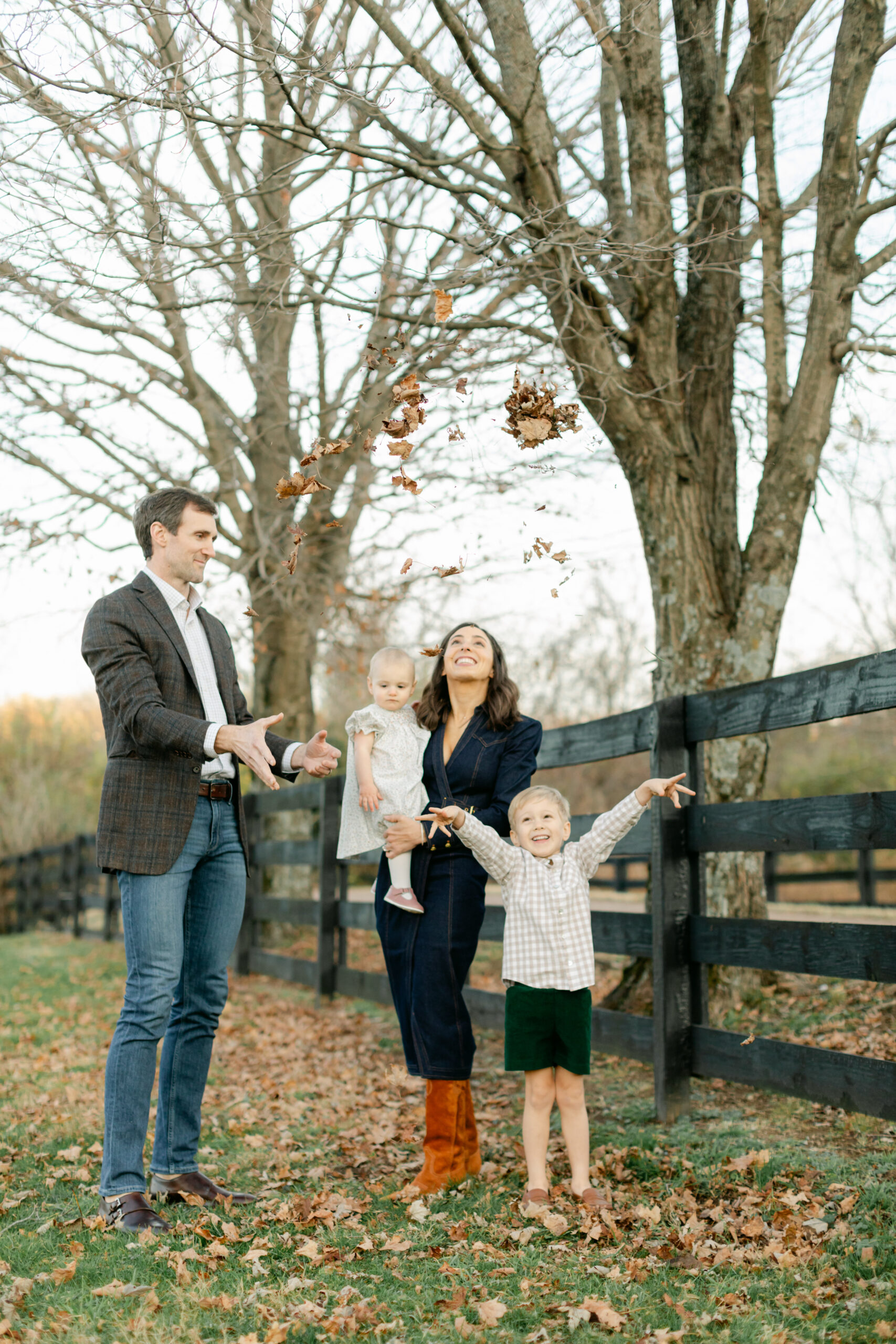 fall family photos in tree filled path. parents with little girl and boy