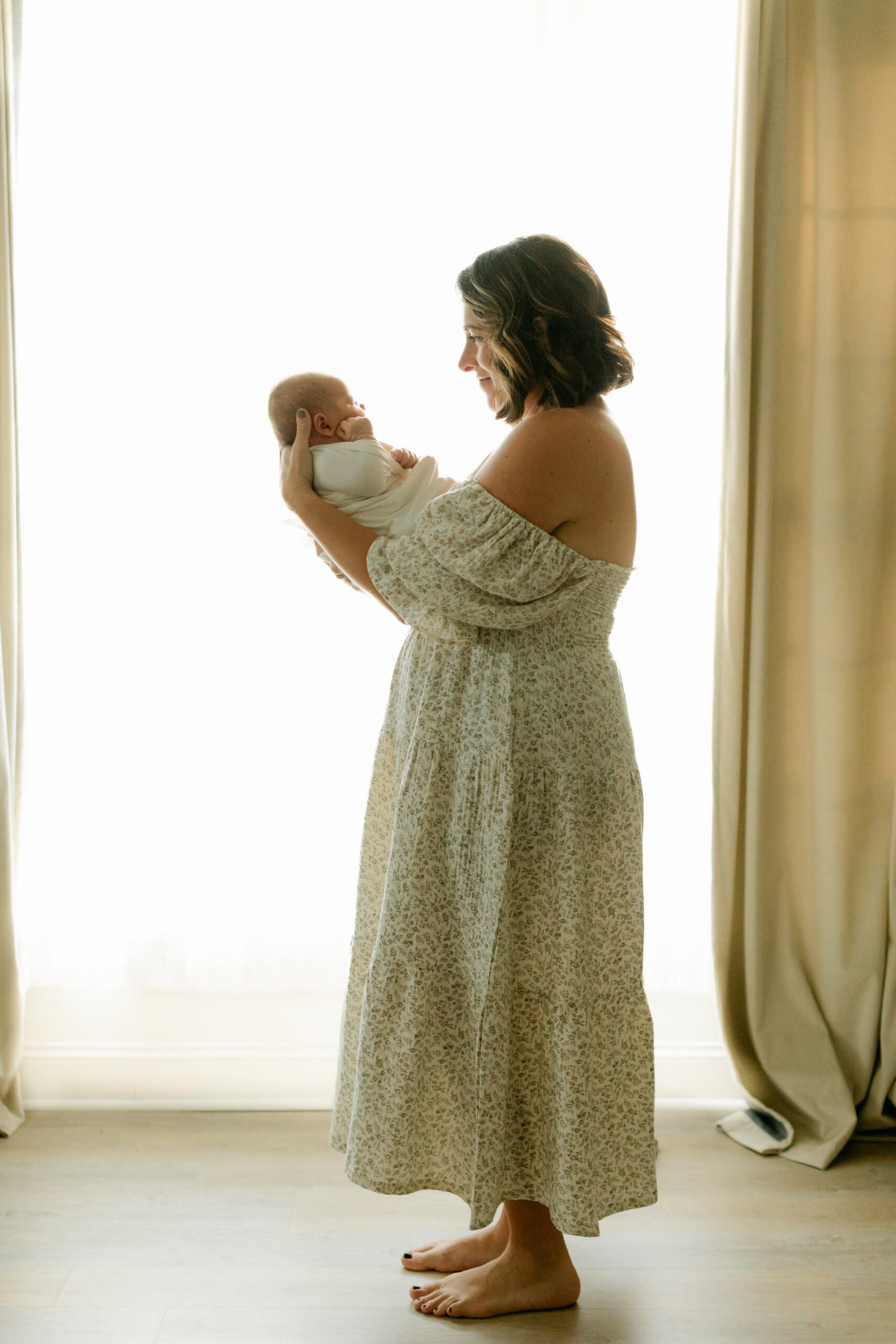 mama in off the shoulder midi dress holding her newborn son