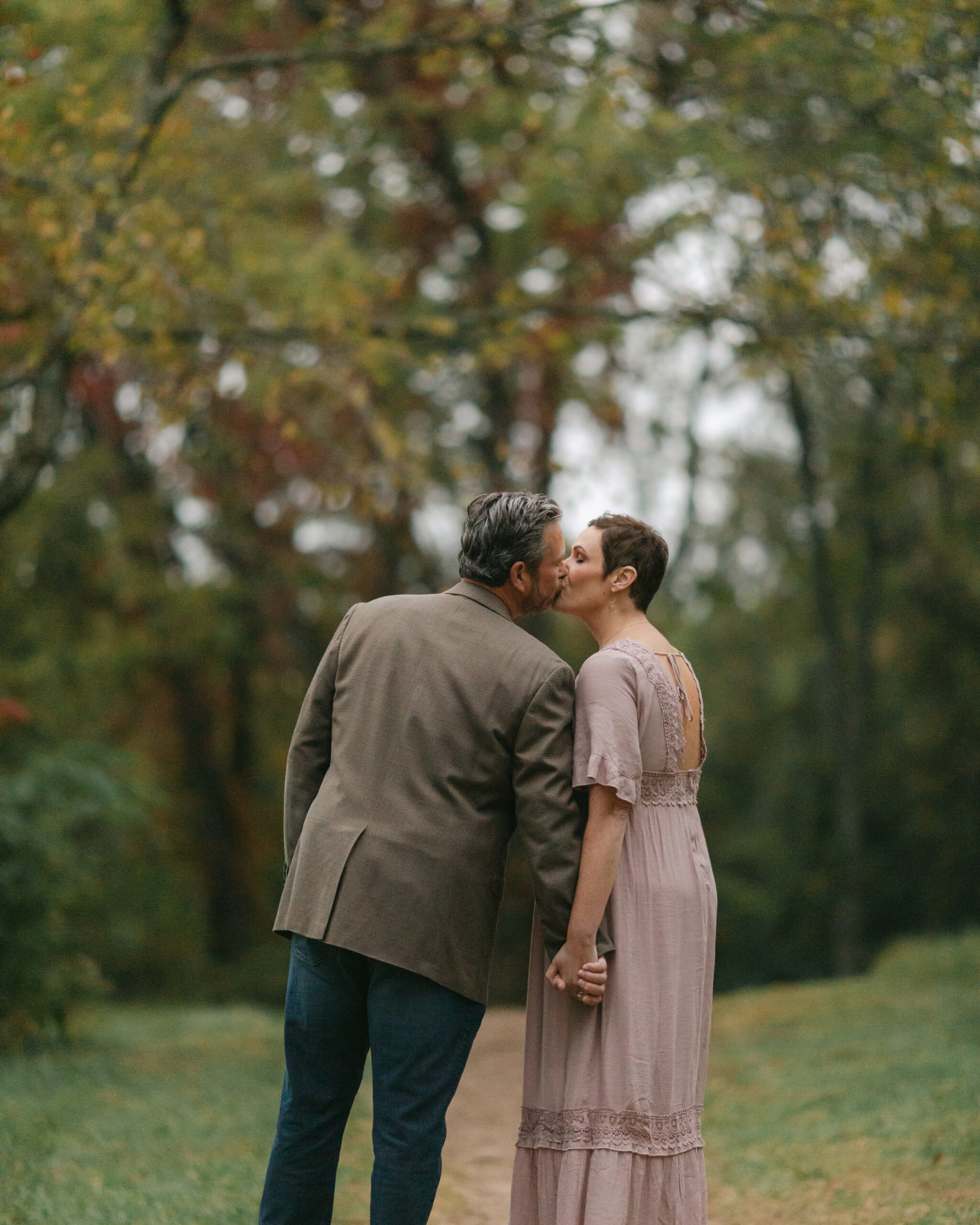 husband wife during fall family photos at the woods