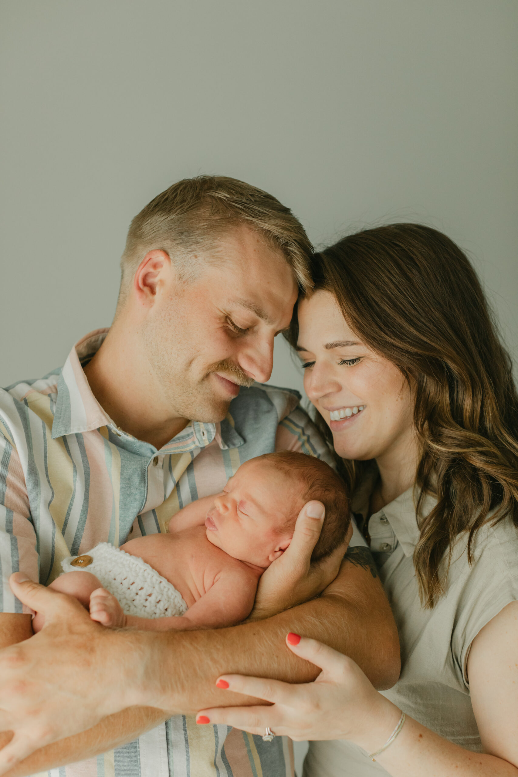 parents in coordinating outfits with newborn baby boy