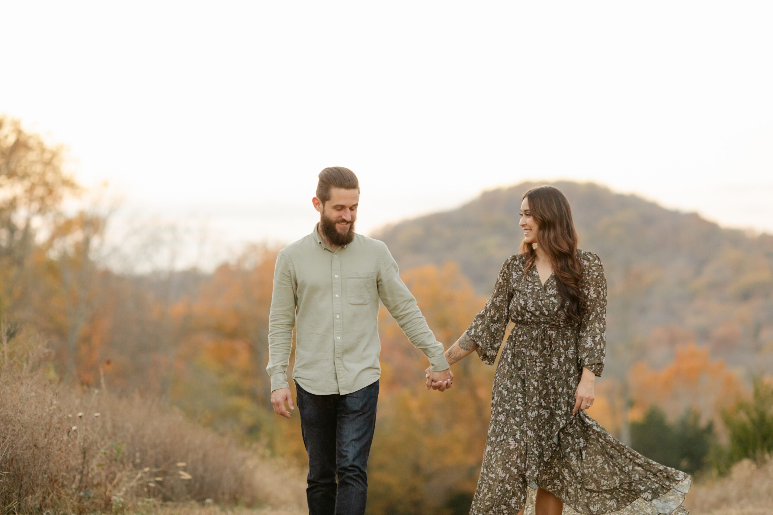 husband and wife walking holding hands during fall family photos