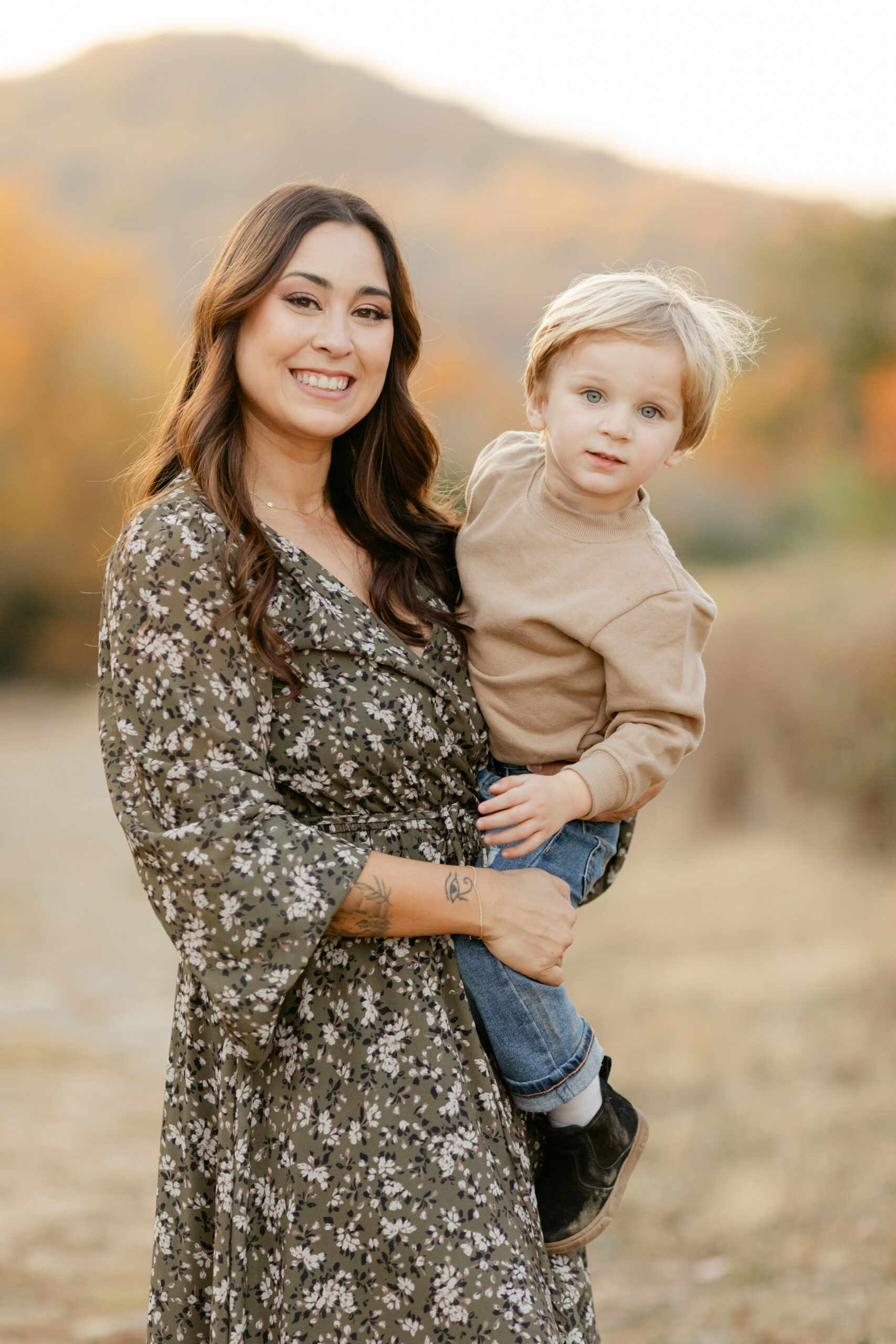 mama and toddler son at top of hill during fall family photos