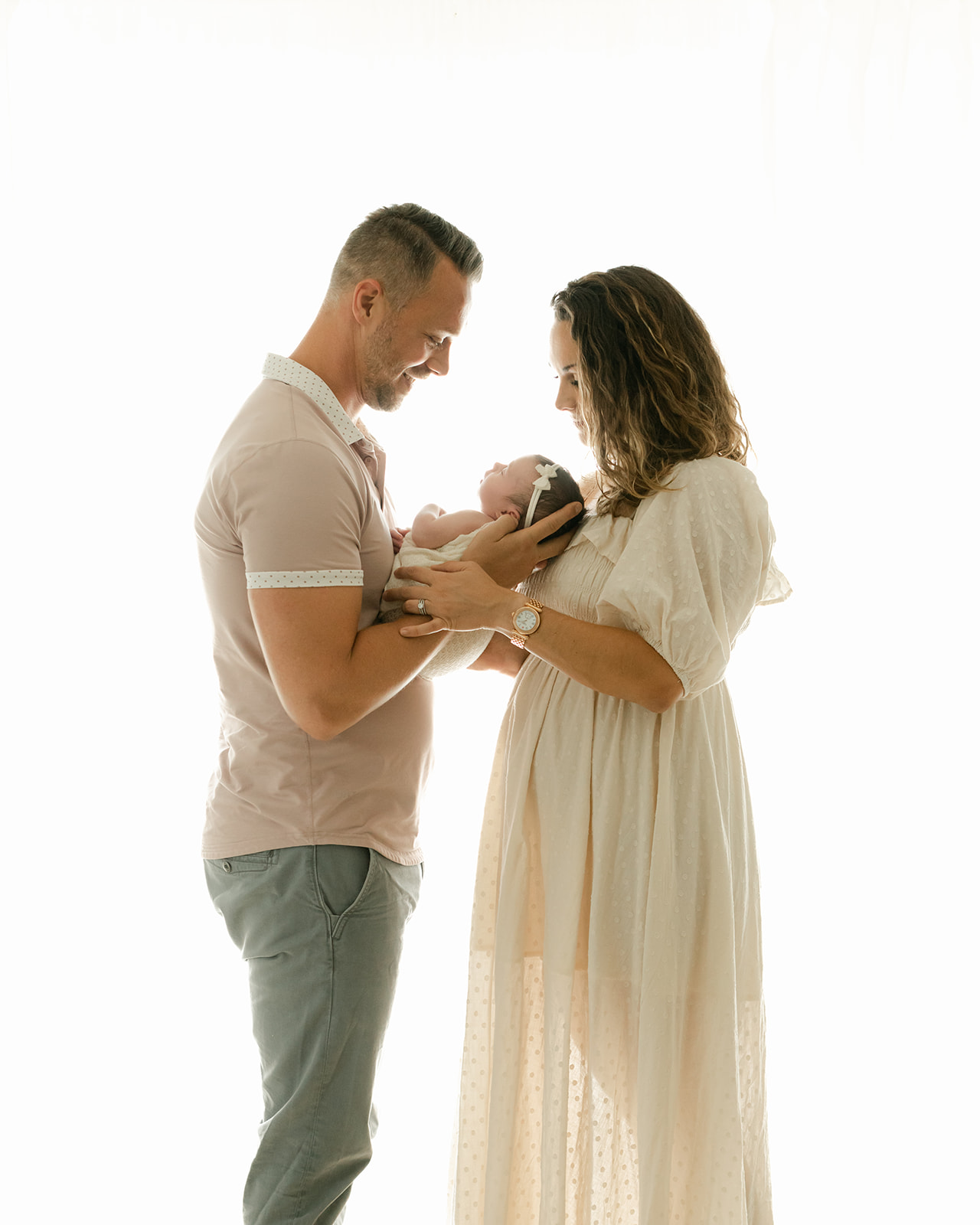 parents with newborn baby girl. mama in cream midi dress