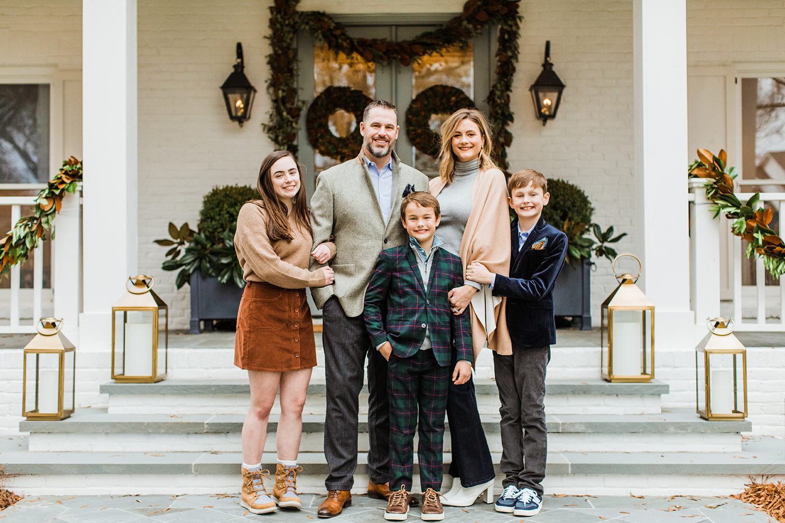 family photo (mom, dad, eldest daughter and two young boys). christmas family photos in front of home