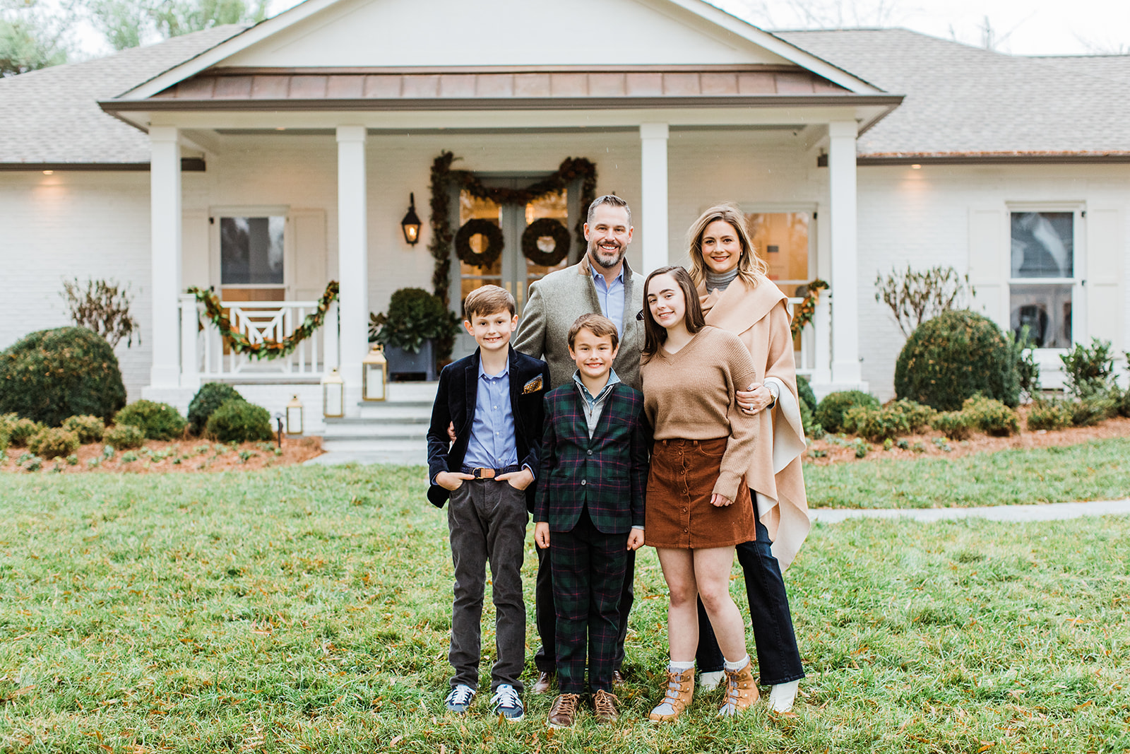 family photo (mom, dad, eldest daughter and two young boys). christmas family photos in front of home