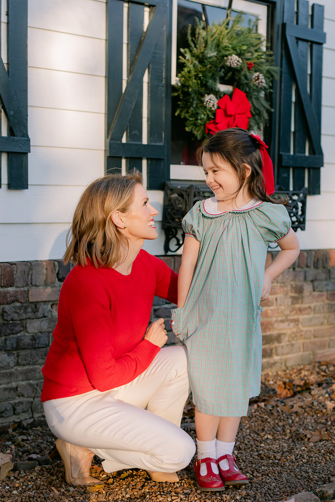 mom and daughter. christmas family photos in front of home