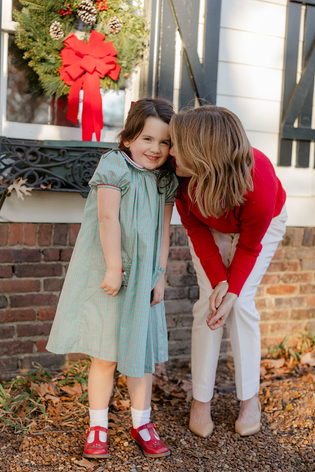 mom and daughter. christmas family photos in front of home