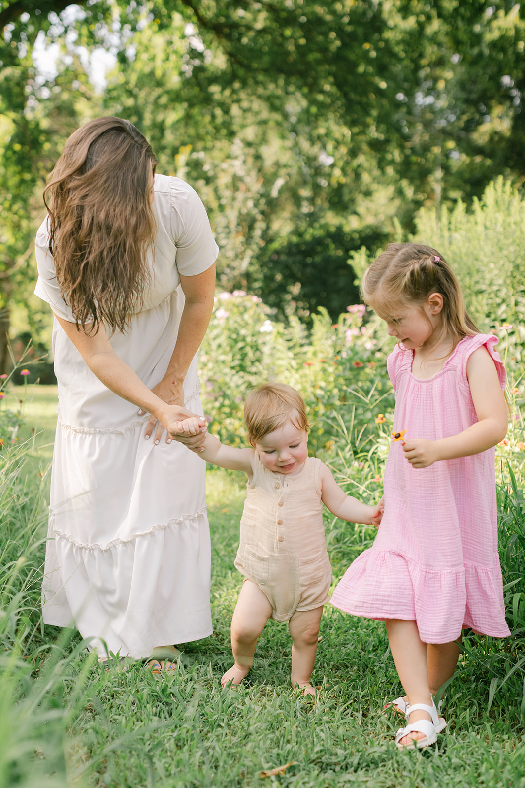 Mom with young daughter and baby boy in flower garden. motherhood minis photo session in nashville