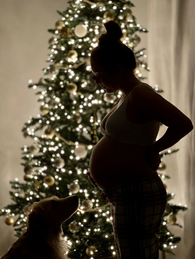 pregnant woman in front of christmas tree