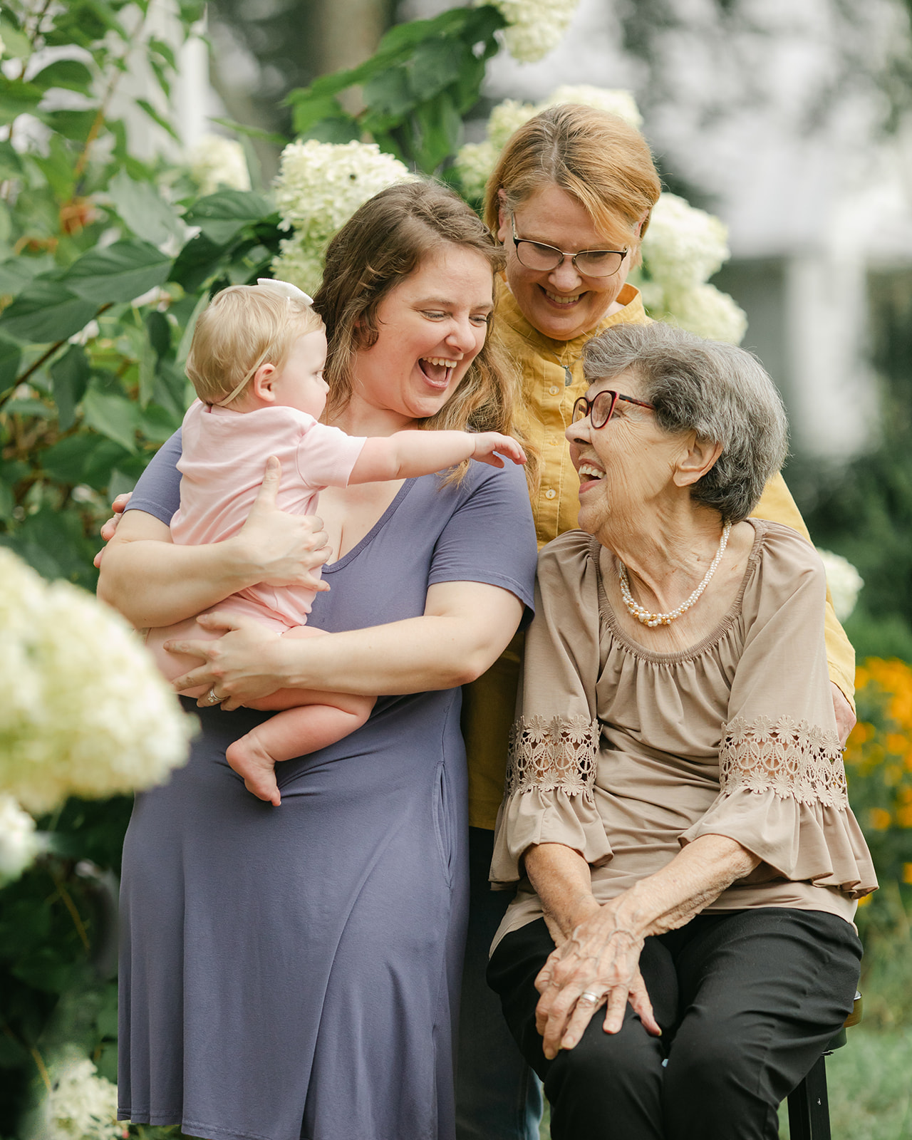 Grandmothers, mom with baby girl in flower garden. motherhood minis photo session in nashville