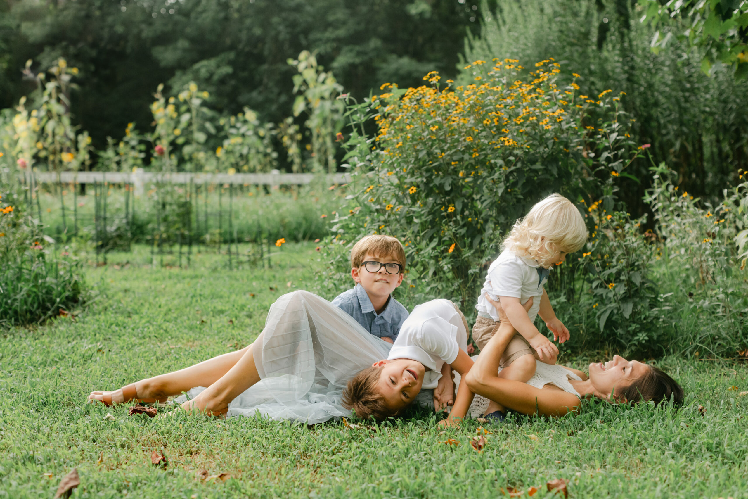 mama and her three young boys in flower garden. motherhood minis photo session in nashville