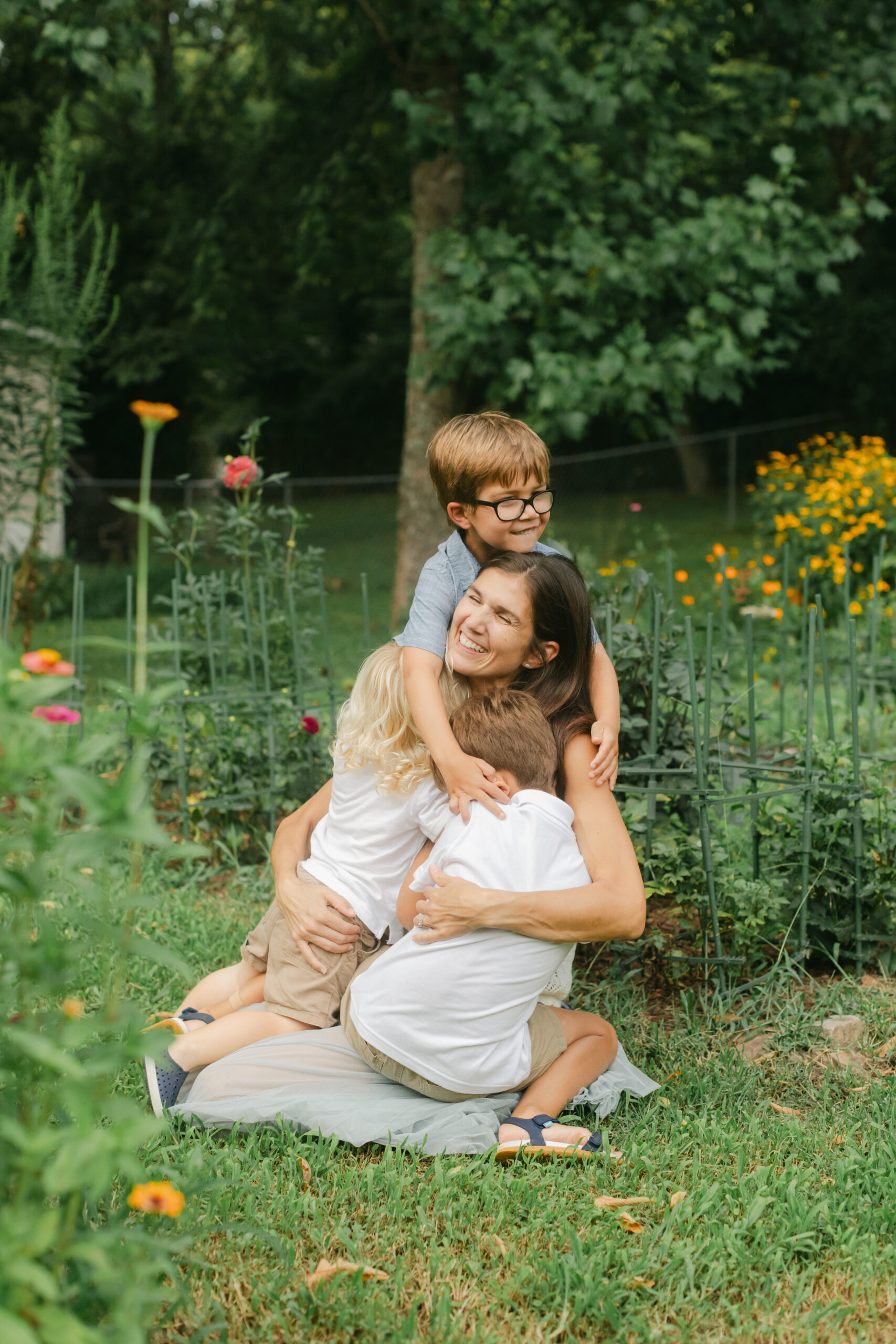 mama and her three young boys in flower garden. motherhood minis photo session in nashville