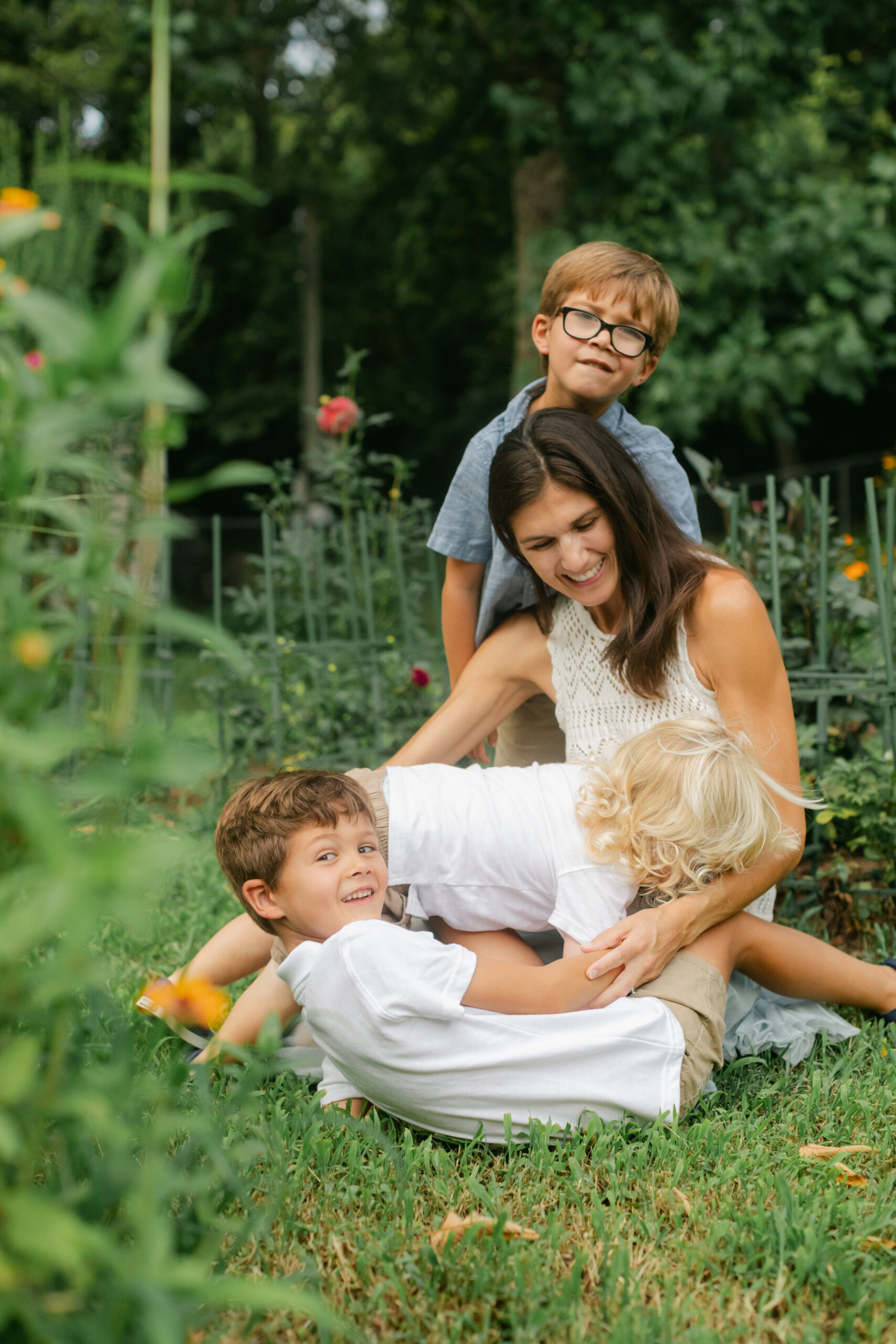 mama and her three young boys in flower garden. motherhood minis photo session in nashville