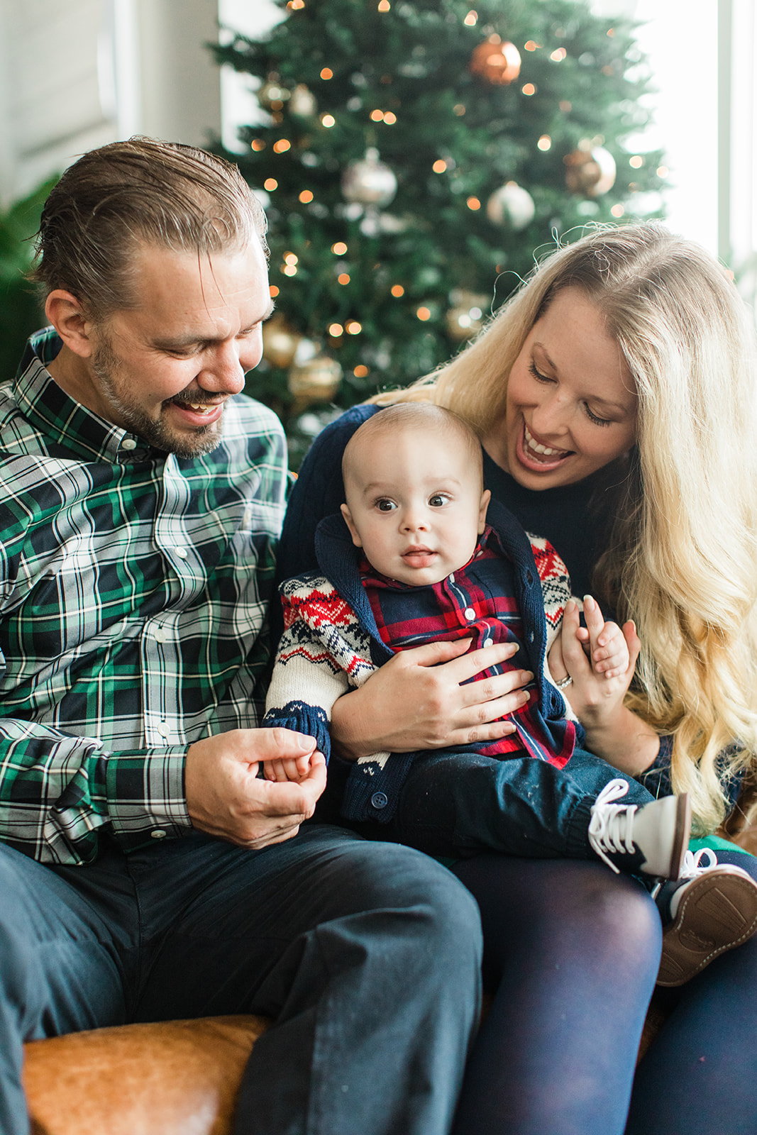 family sitting on couch. christmas family photos in living room