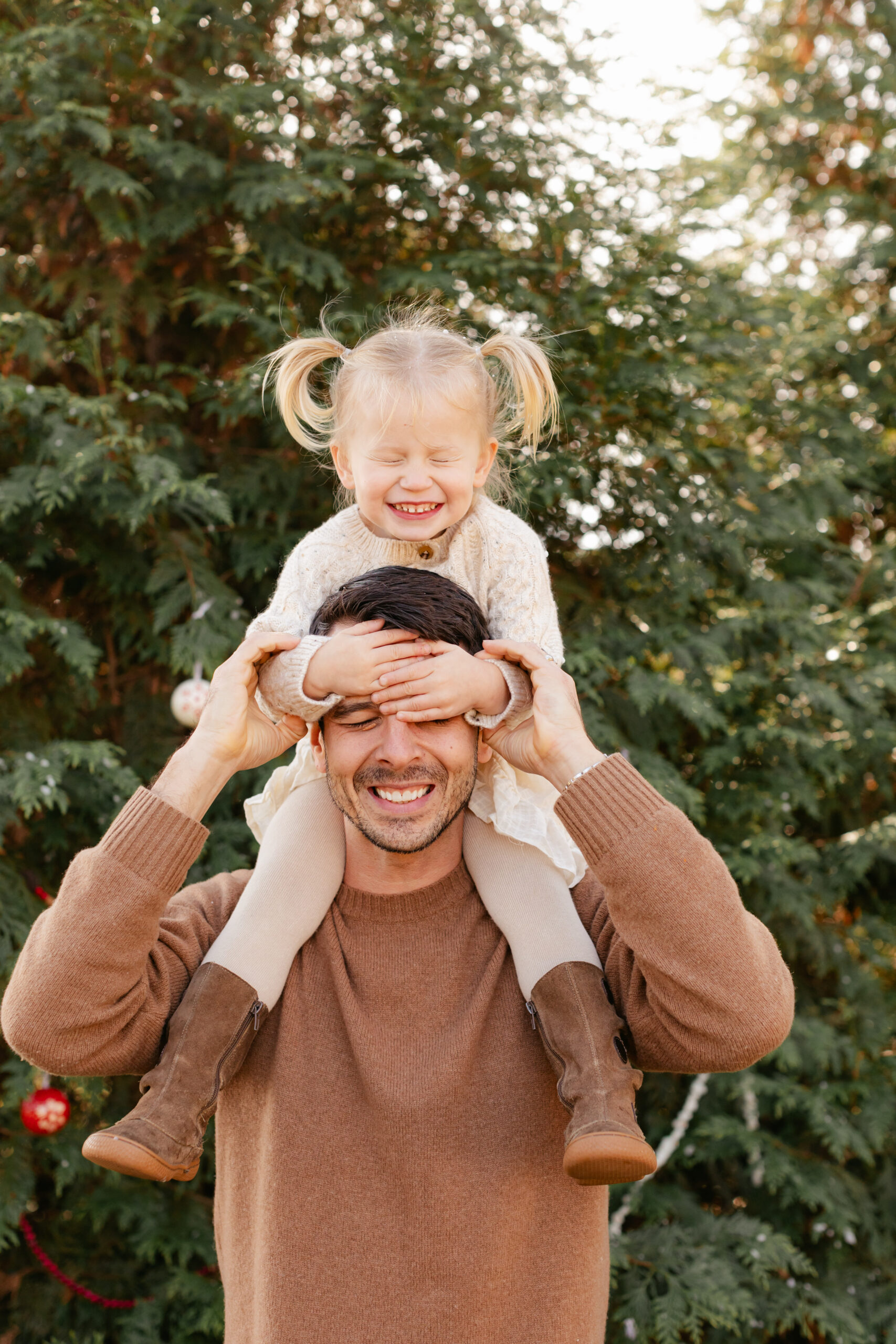 dad with young daughter on shoulders. christmas themed family photos in tennessee with fake snow