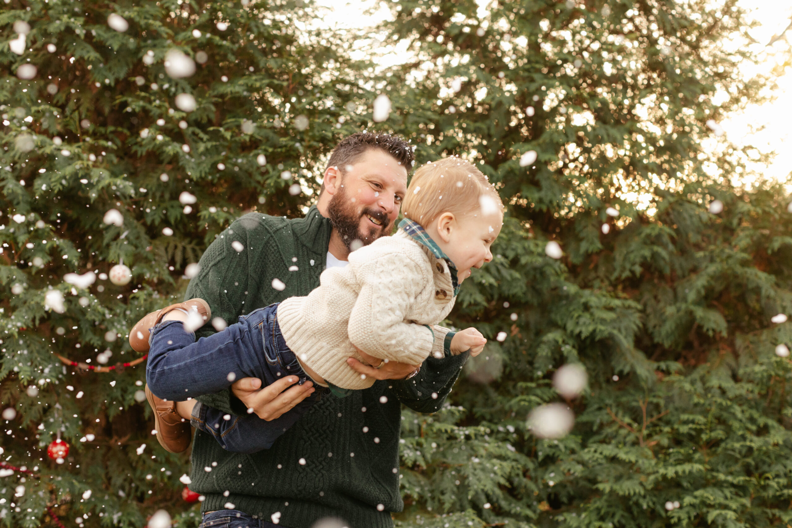 dad with son.  christmas themed family photos in tennessee with fake snow