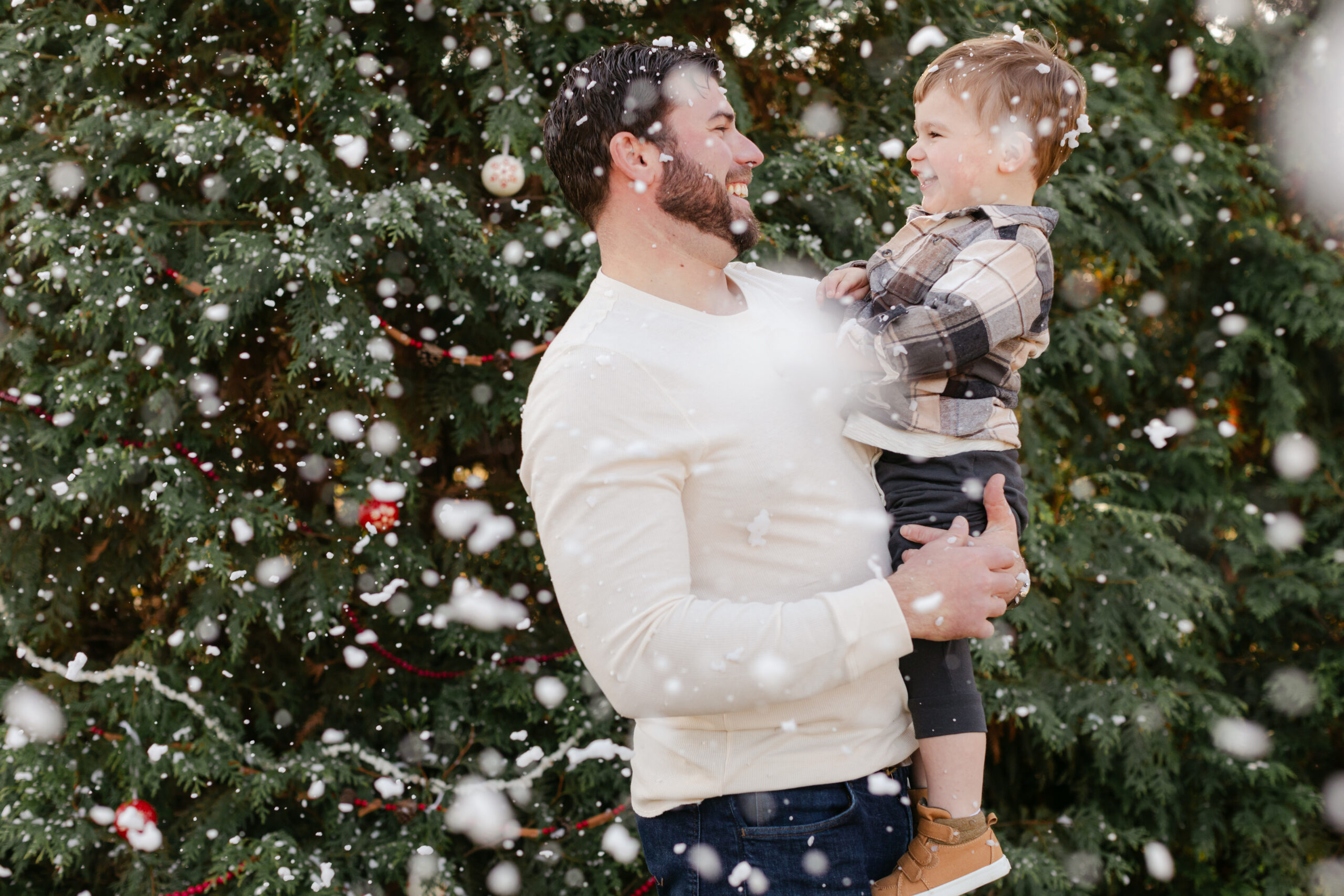 dad with son.  christmas themed family photos in tennessee with fake snow