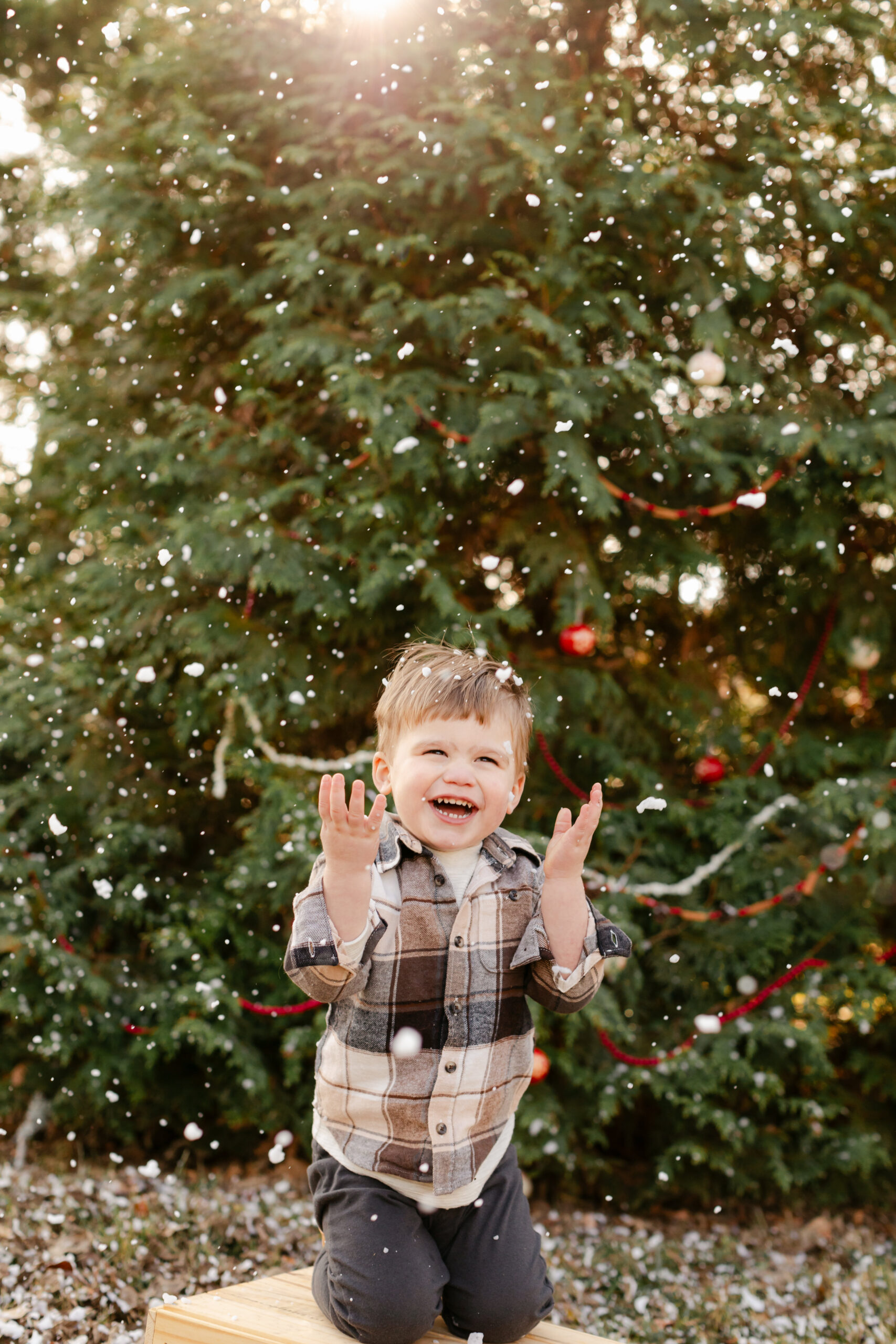 baby boy playing with snow.  christmas themed family photos in tennessee with fake snow