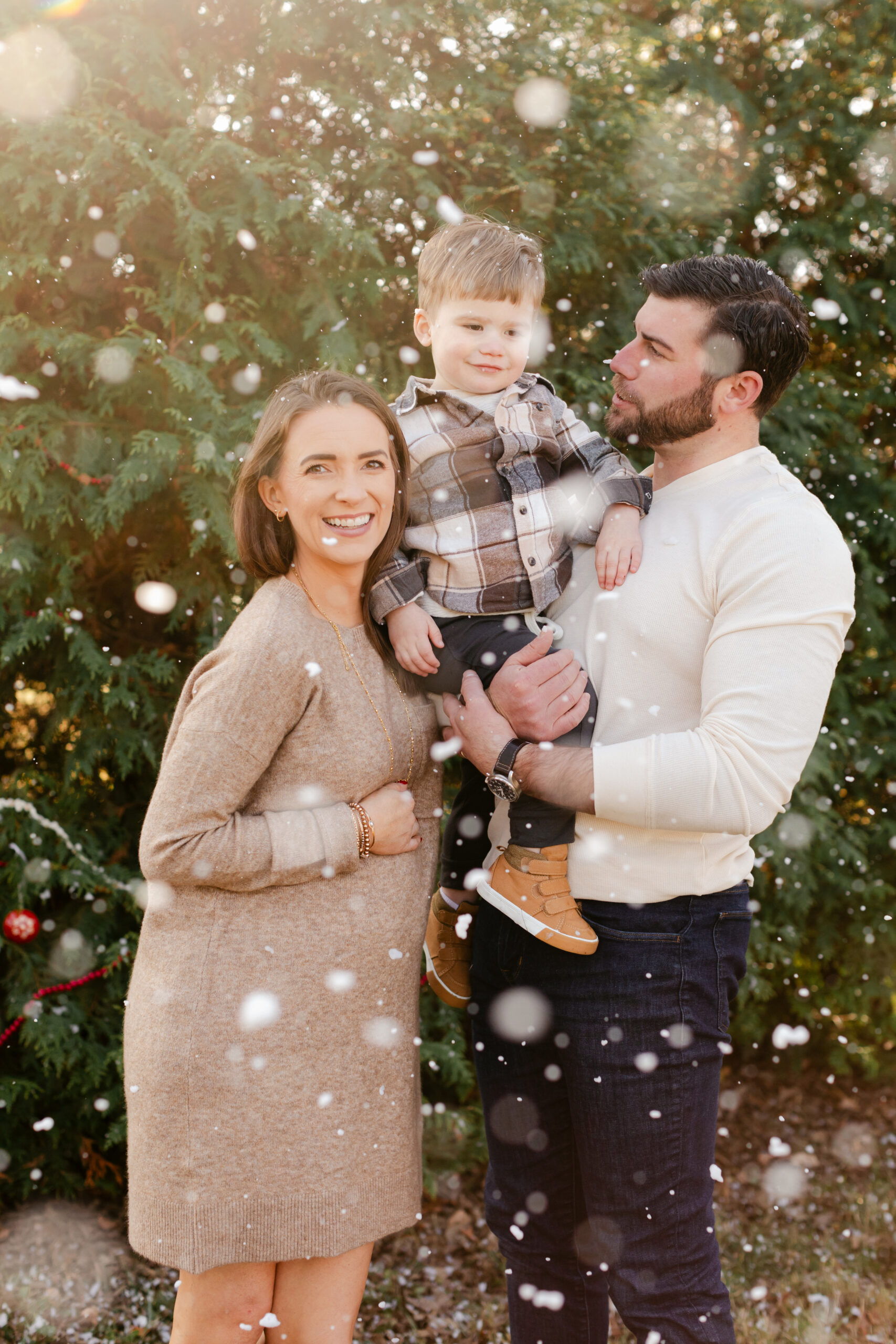 parents with baby boy.  christmas themed family photos in tennessee with fake snow