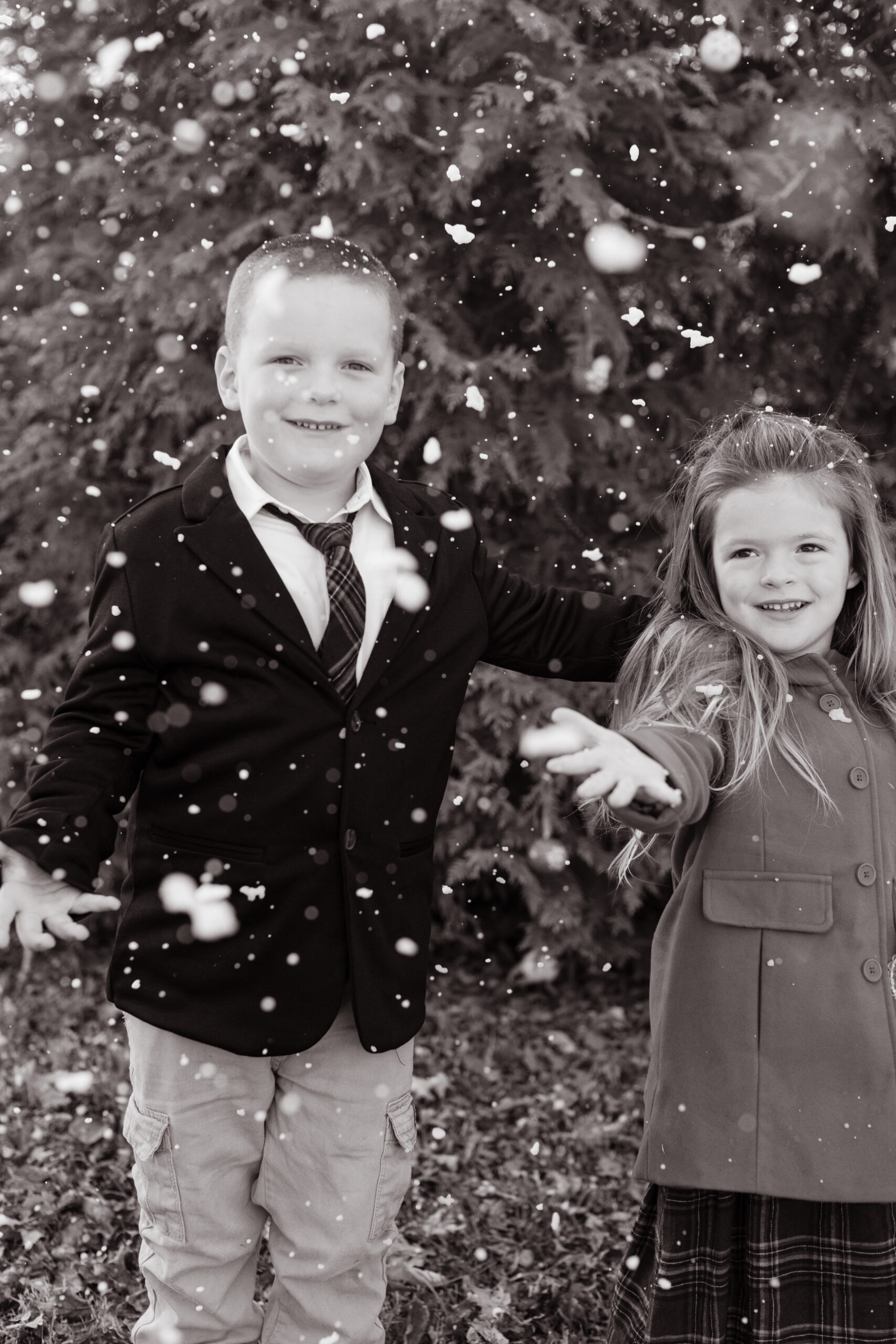 siblings playing with snow.  christmas themed family photos in tennessee with fake snow