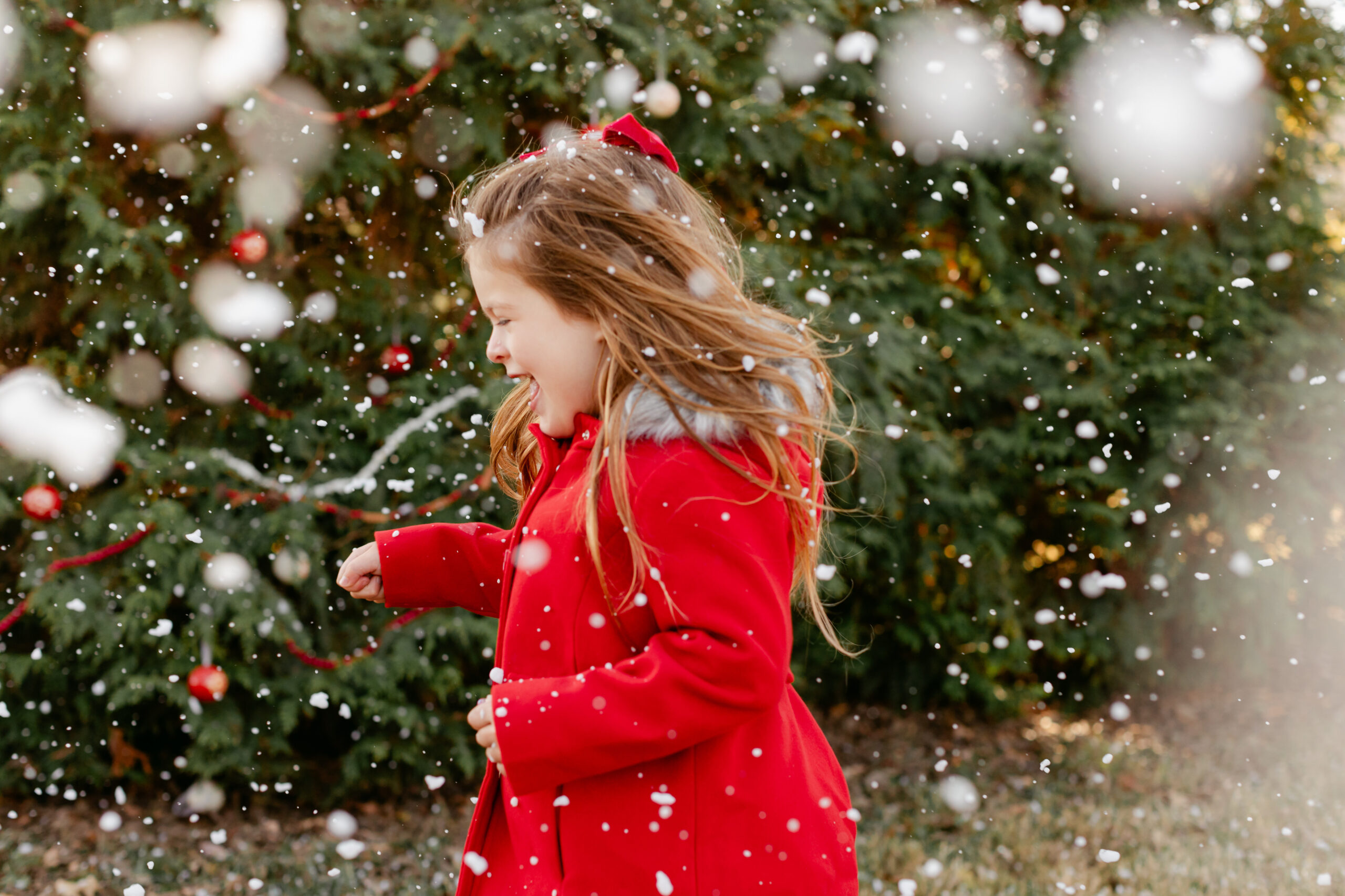 little girl in red coat.  christmas themed family photos in tennessee with fake snow