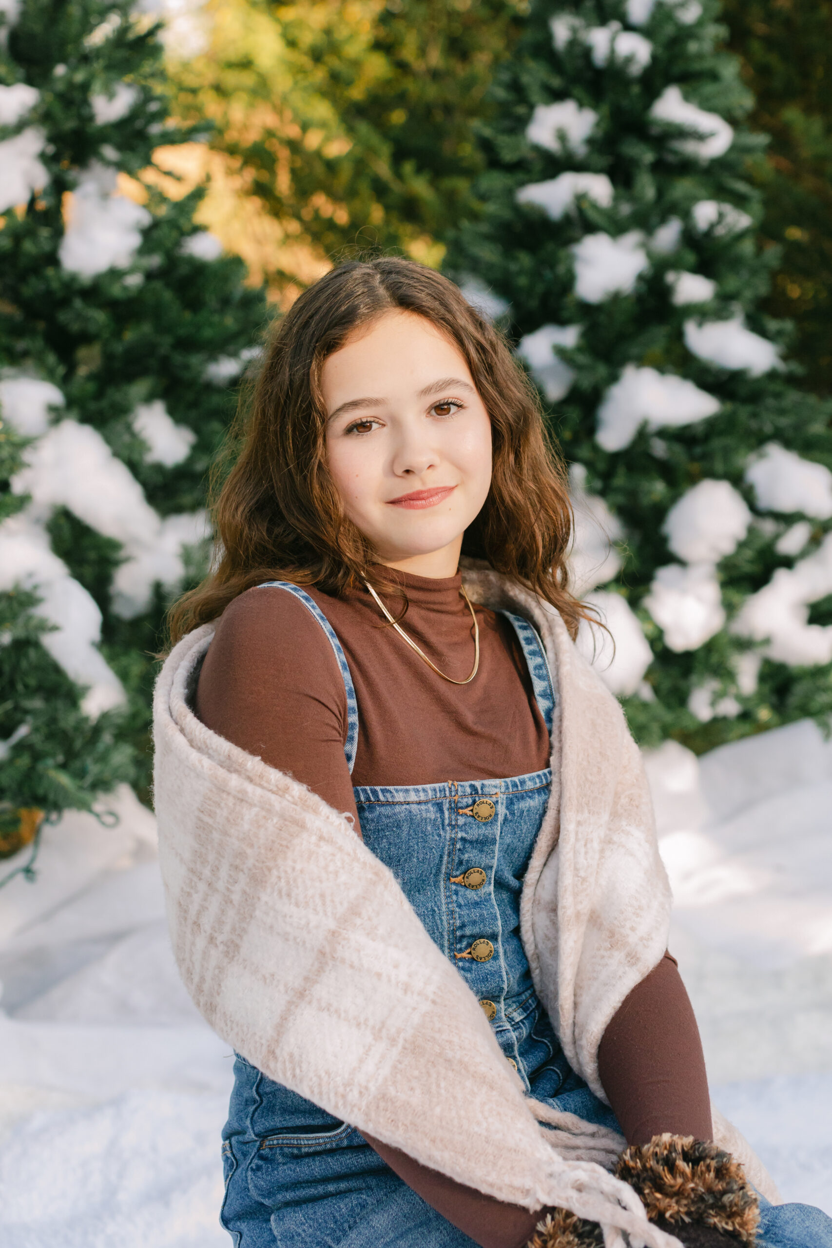 young teen girl in cute winter outfit playing with fake snow during snow minis