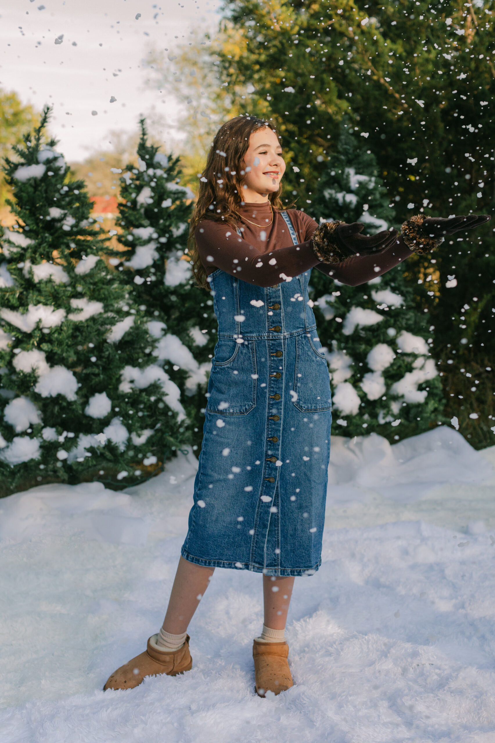 young teen girl in cute winter outfit playing with fake snow during snow minis