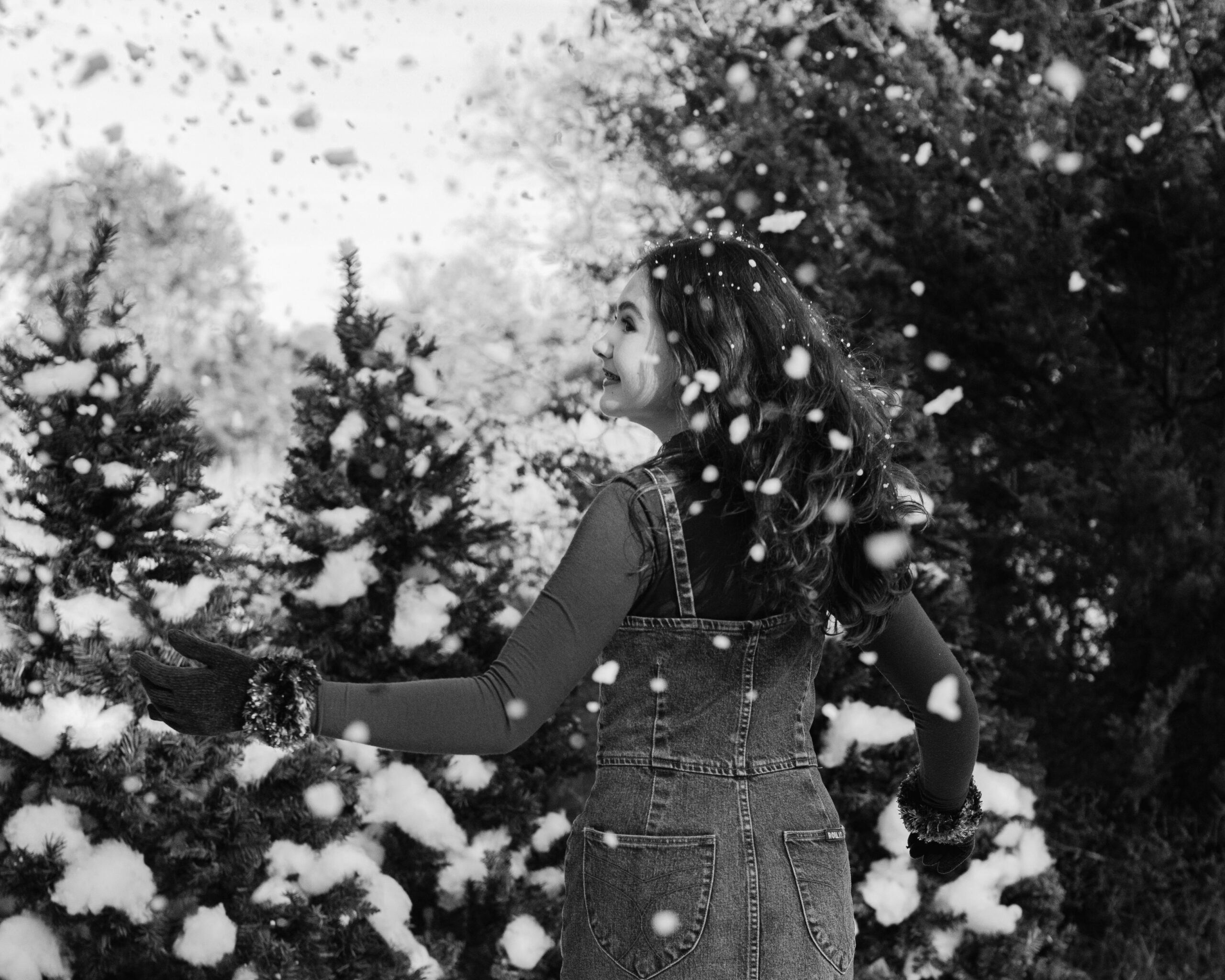 young teen girl in cute winter outfit playing with fake snow during snow minis