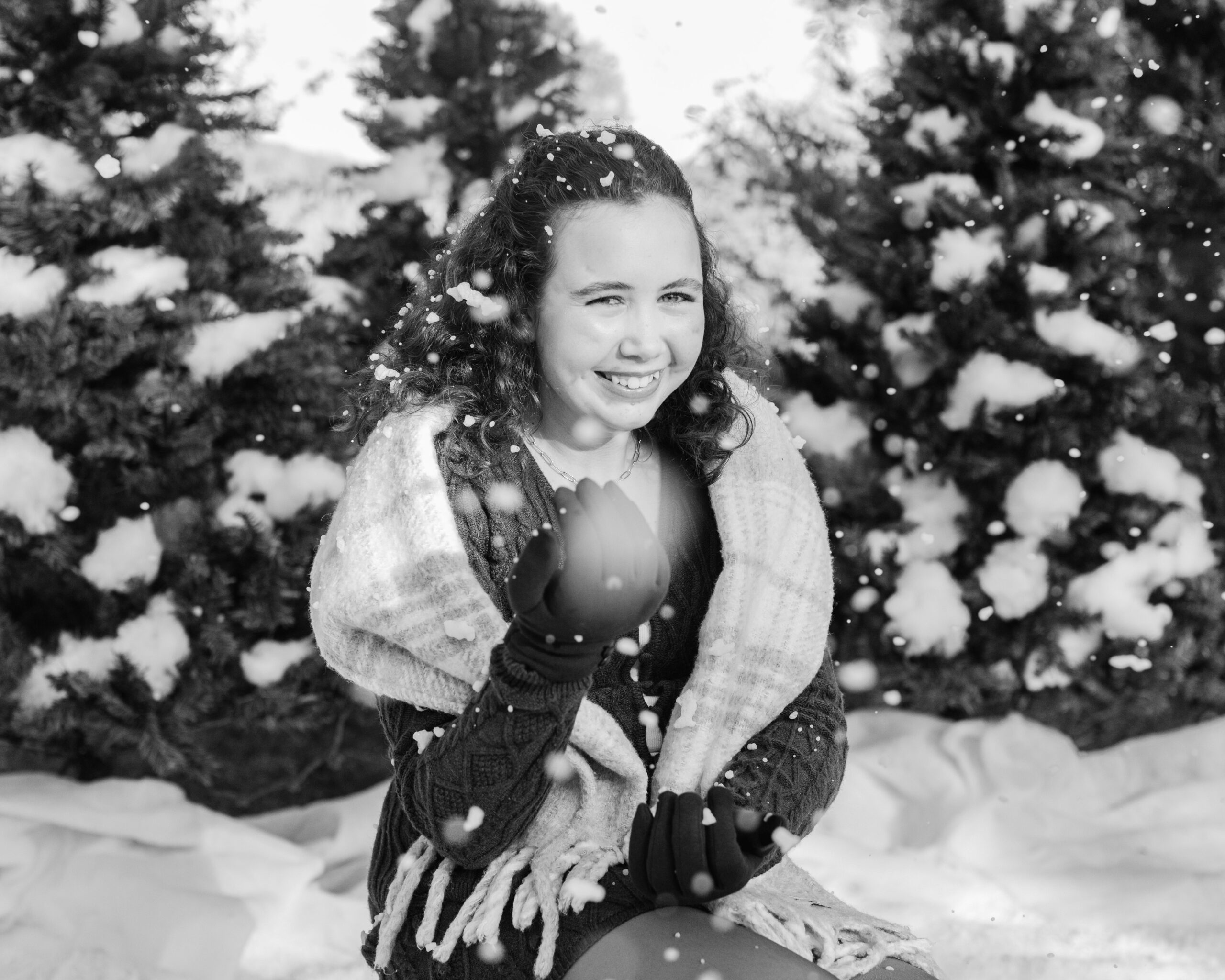 young teen girl in cute winter outfit playing with fake snow during snow minis