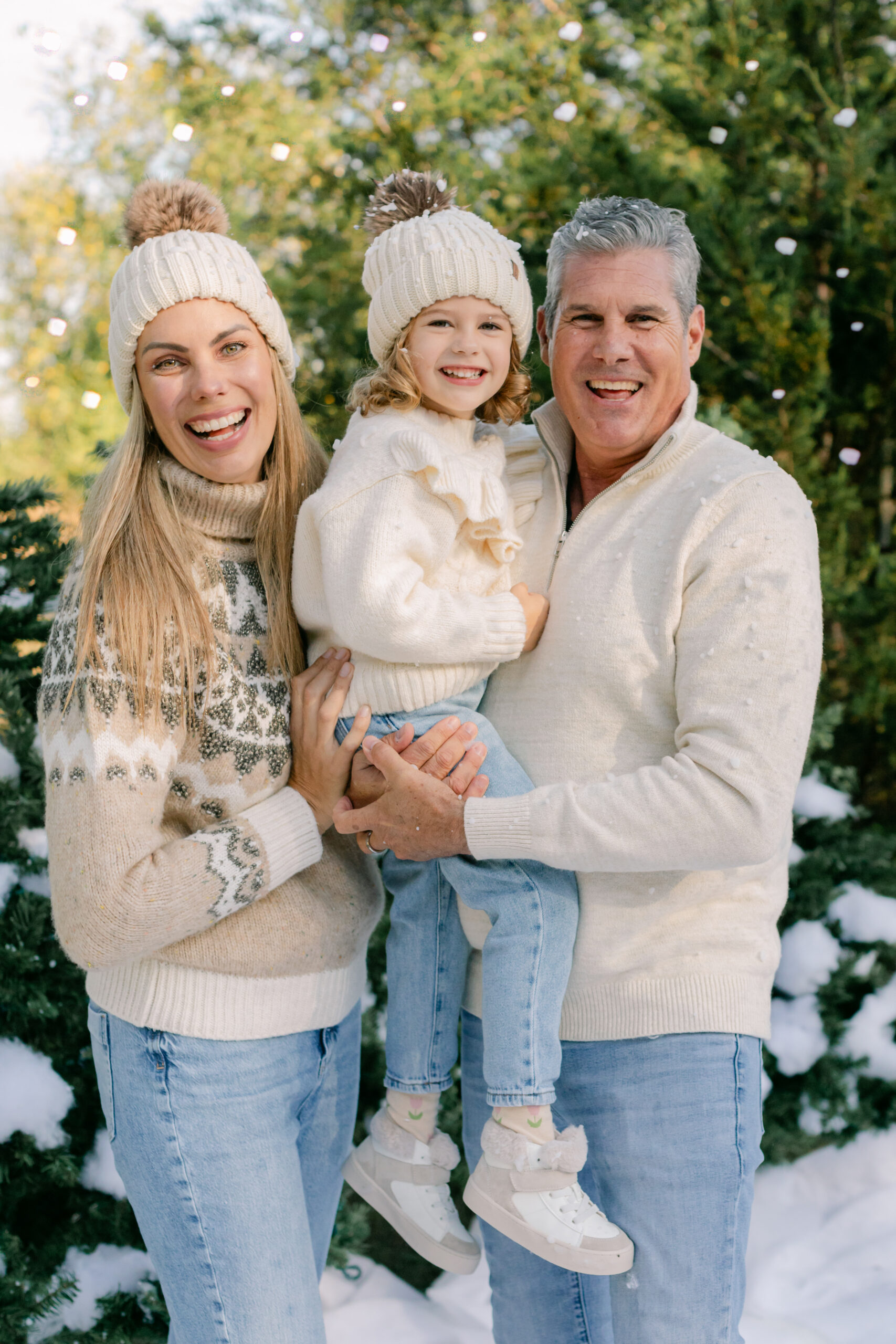 snow minis christmas family photos. mom, dad and baby girl surrounded by fake snow