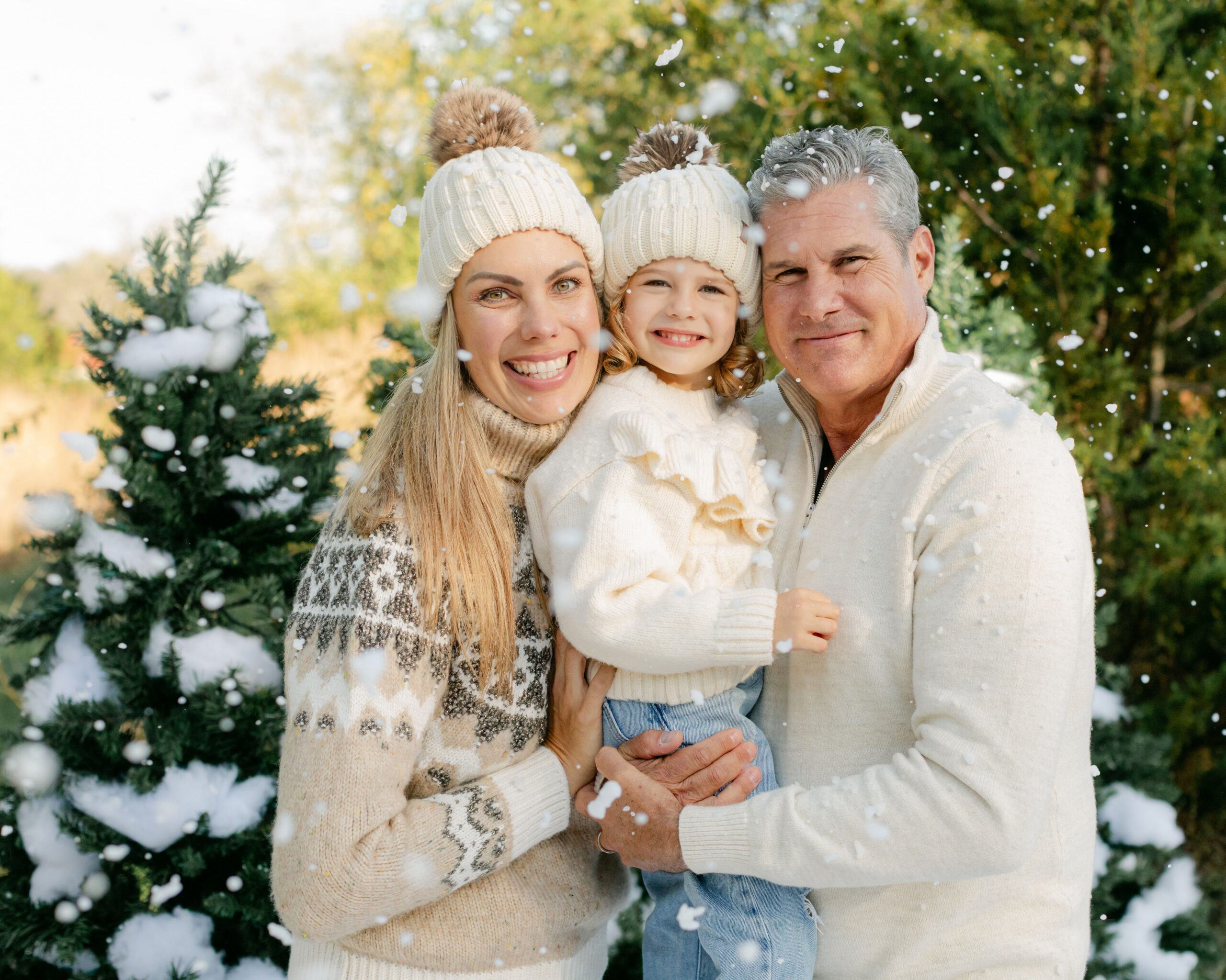 snow minis christmas family photos. mom, dad and baby girl surrounded by fake snow