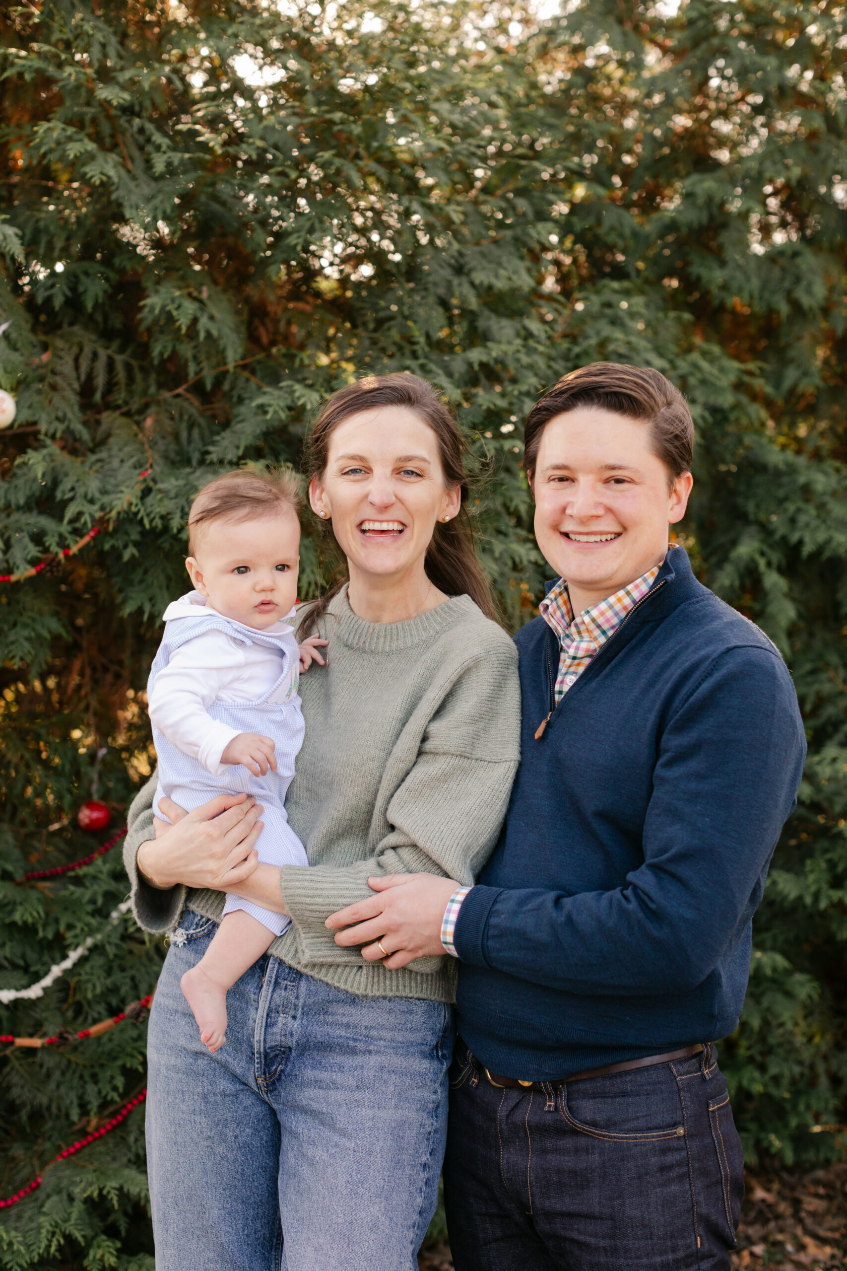 parents with baby.  christmas themed family photos in tennessee with fake snow