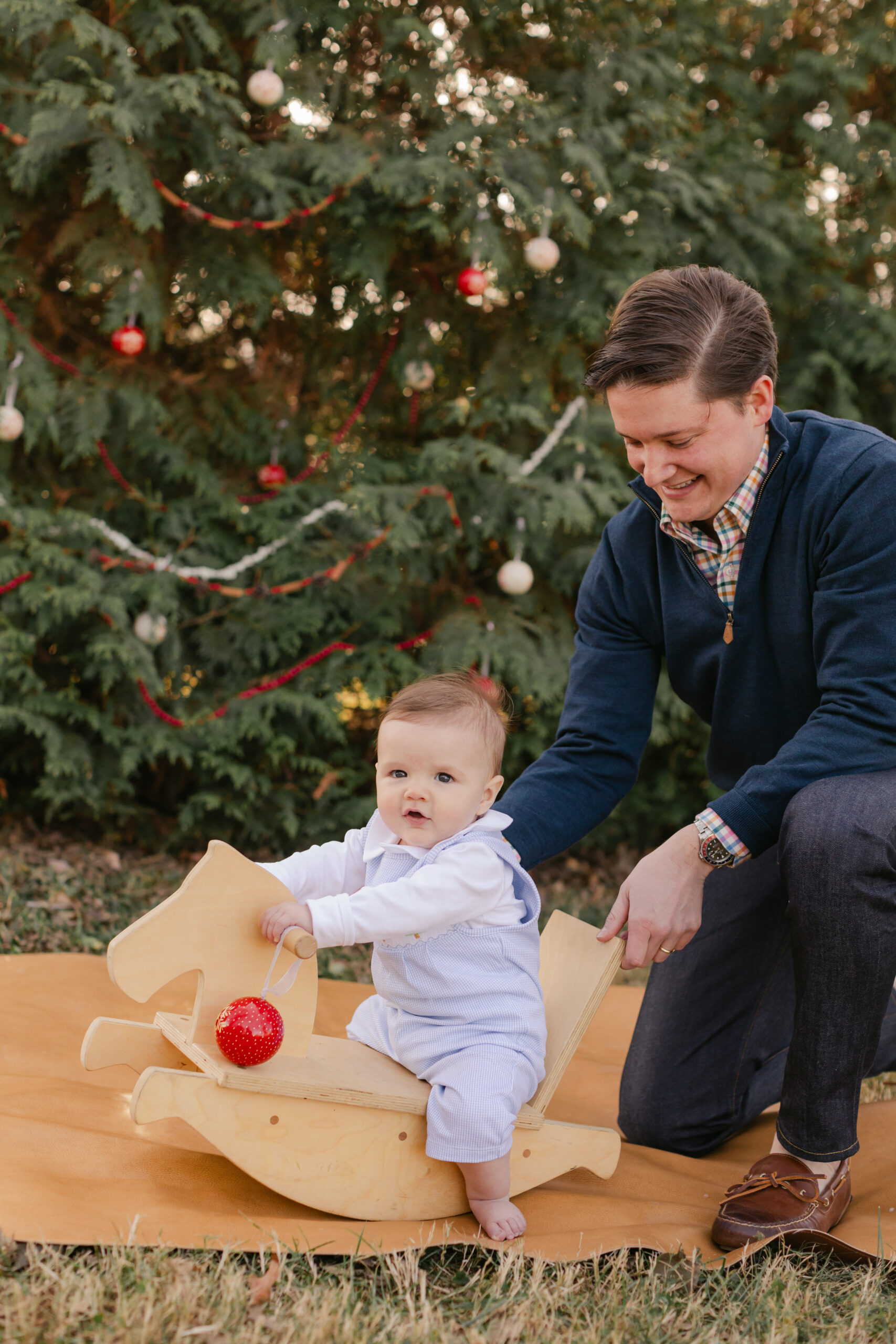 parent with baby.  christmas themed family photos in tennessee with fake snow