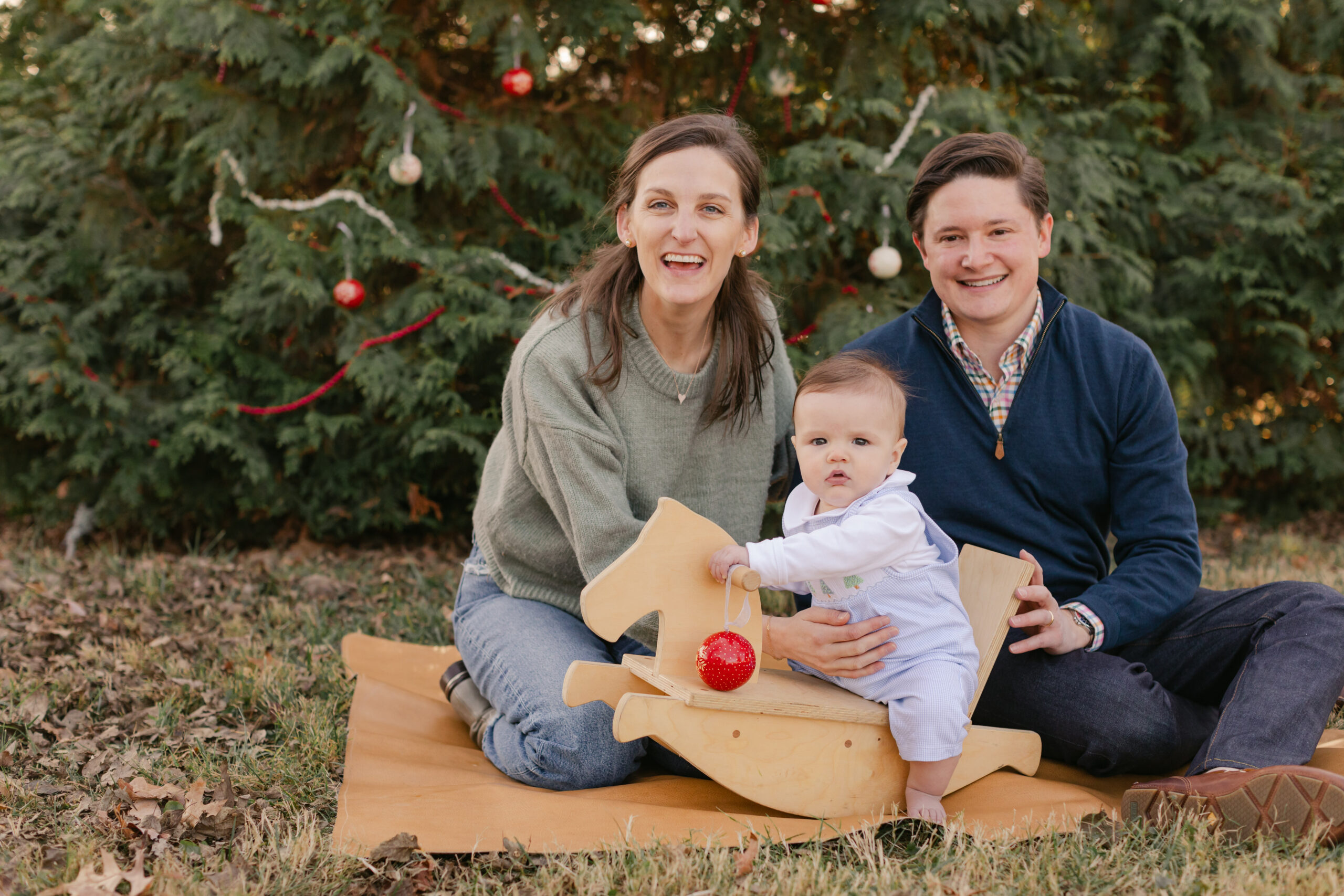 parents with baby. christmas themed family photos in tennessee with fake snow