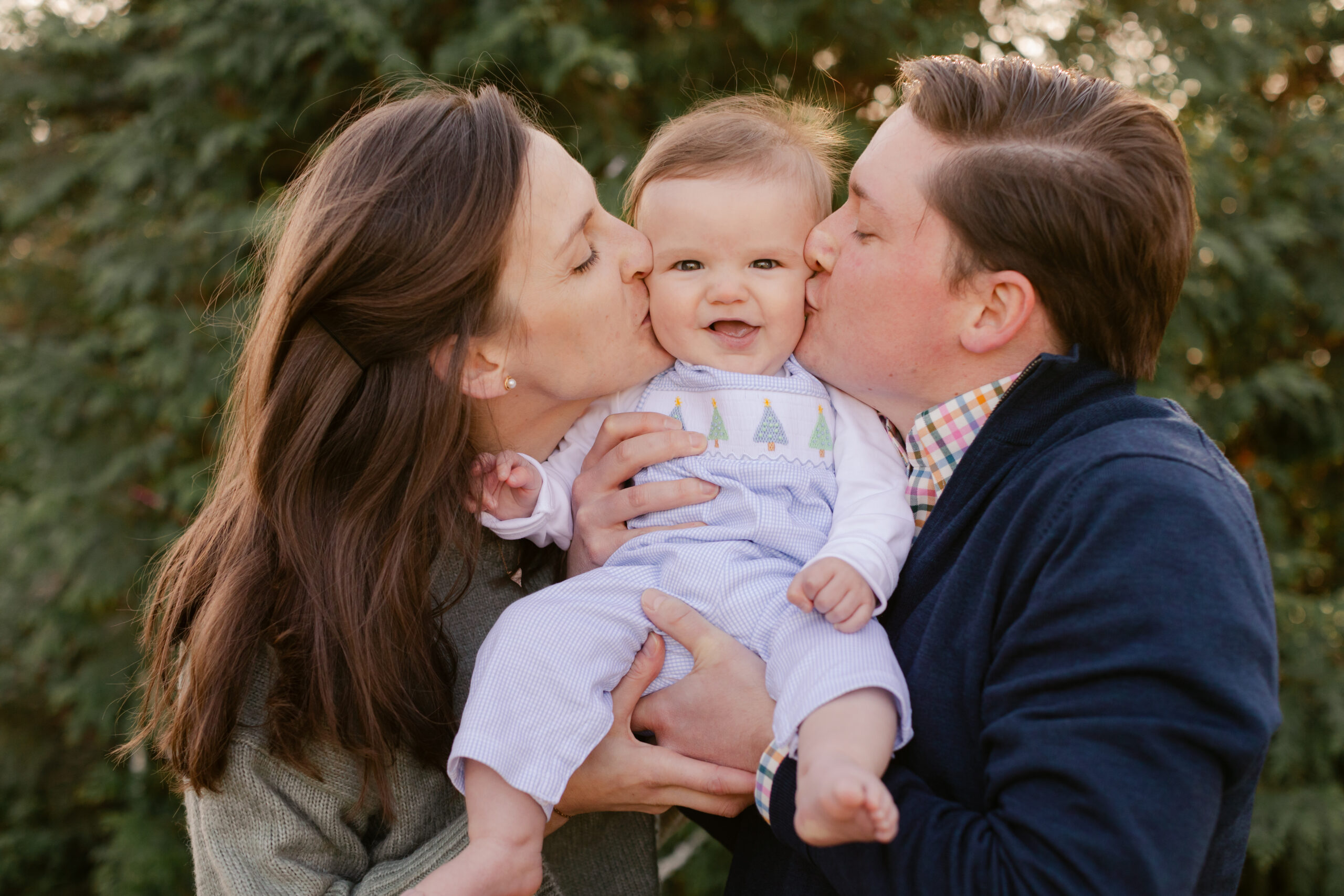 parents with baby.  christmas themed family photos in tennessee with fake snow