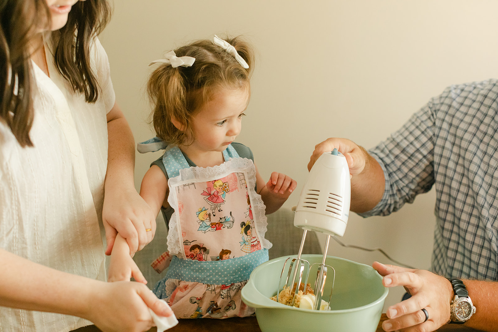 little girl and parents baking cookies