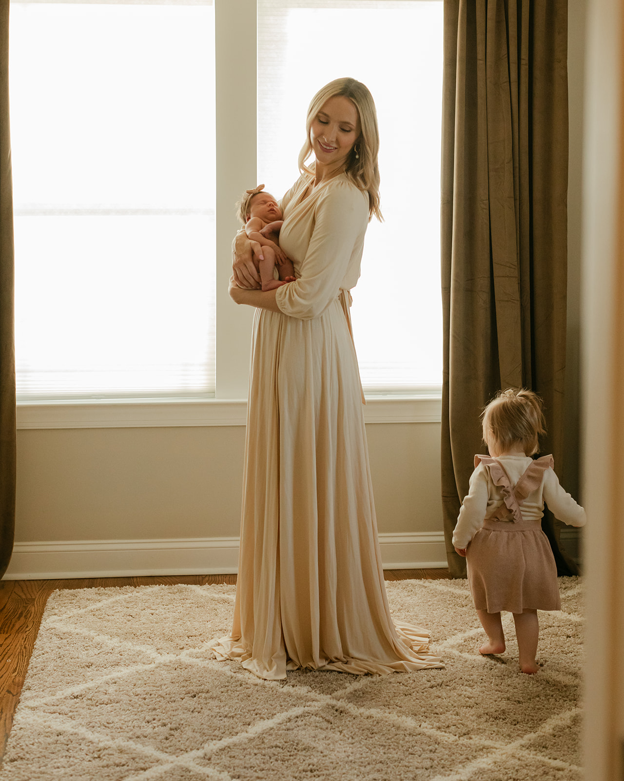 mama in nursery with newborn daughter and toddler