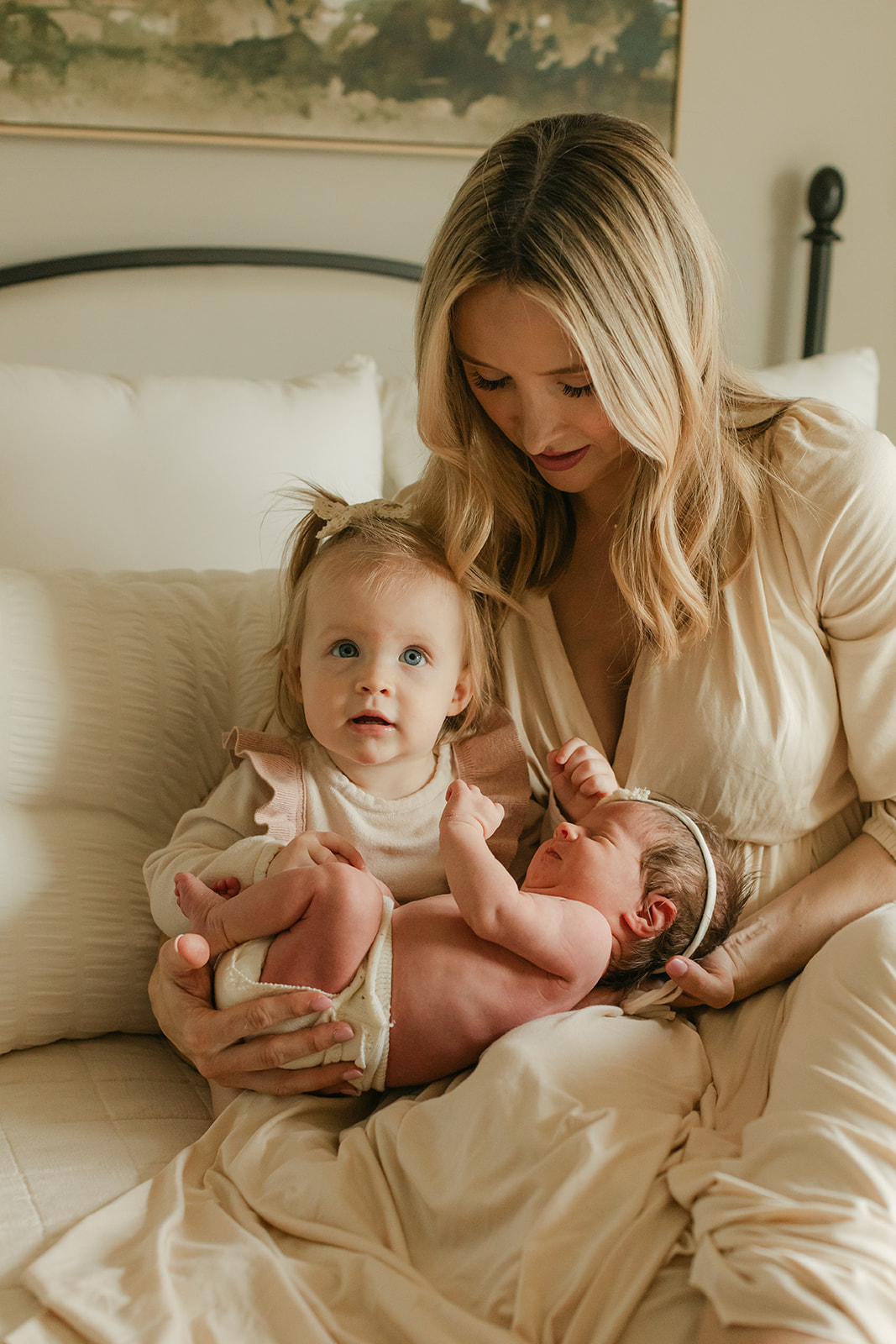 mama with her two daughters. newborn session in nursery