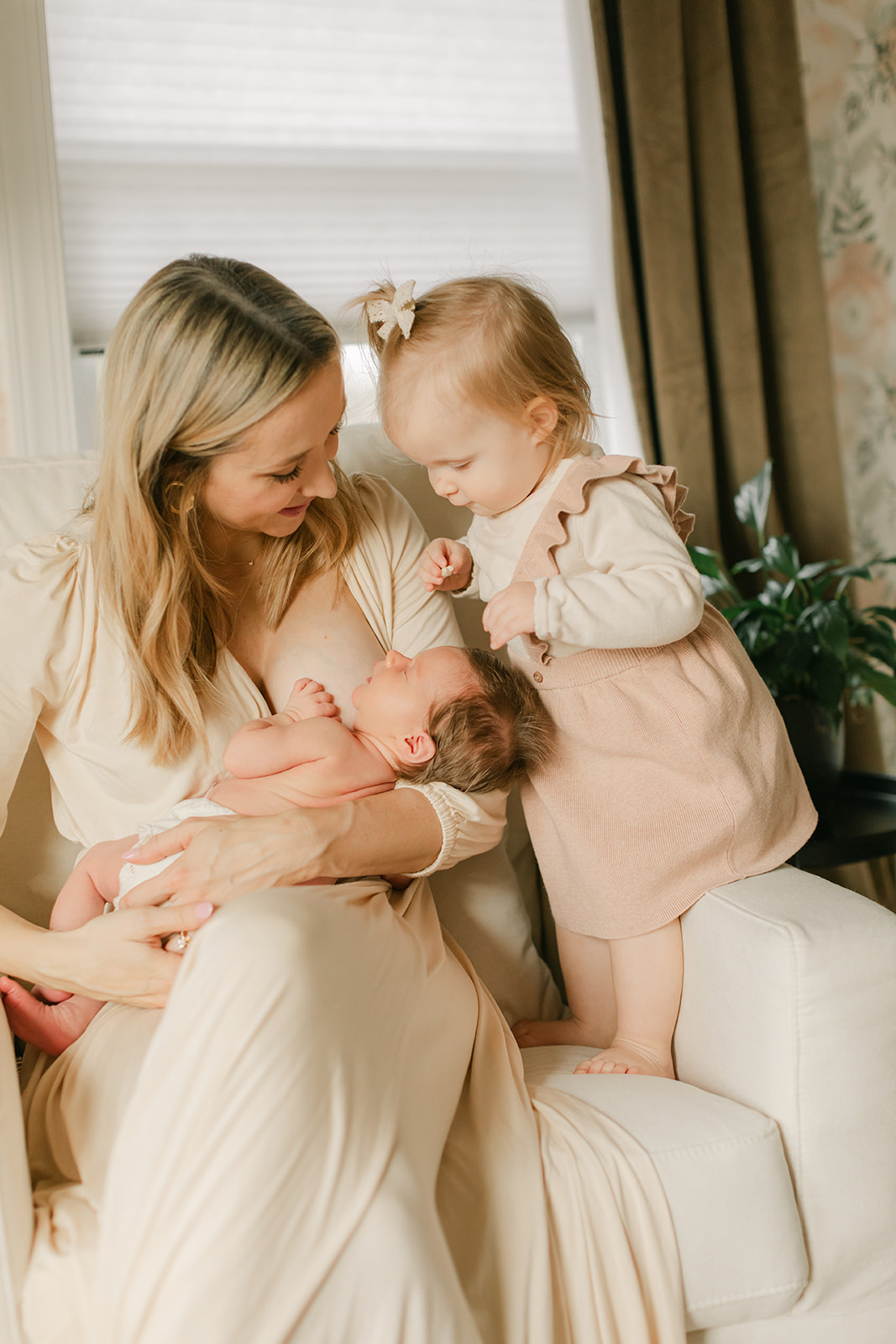 mama with her two daughters. newborn session in nursery