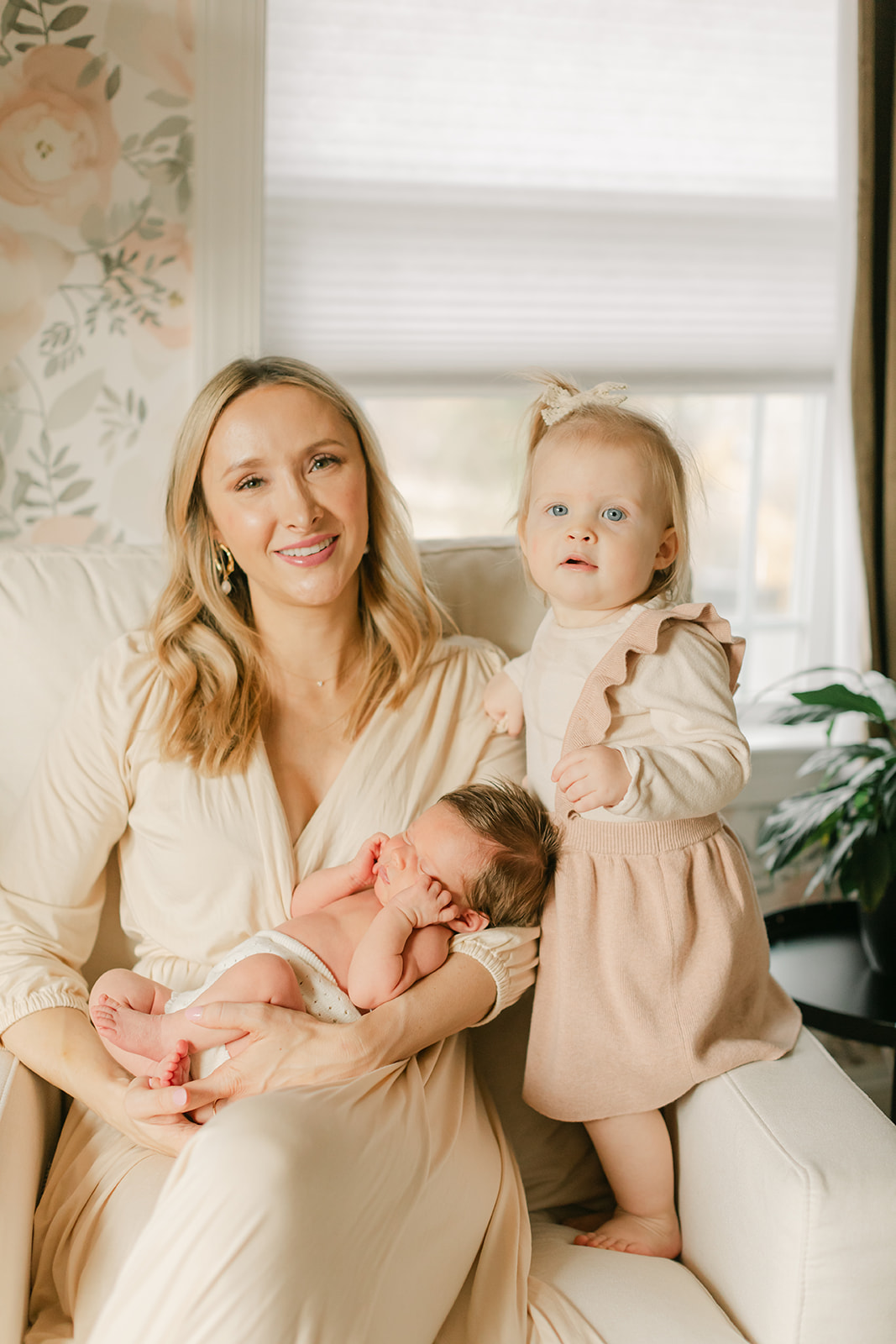 mama with her two daughters. newborn session in nursery