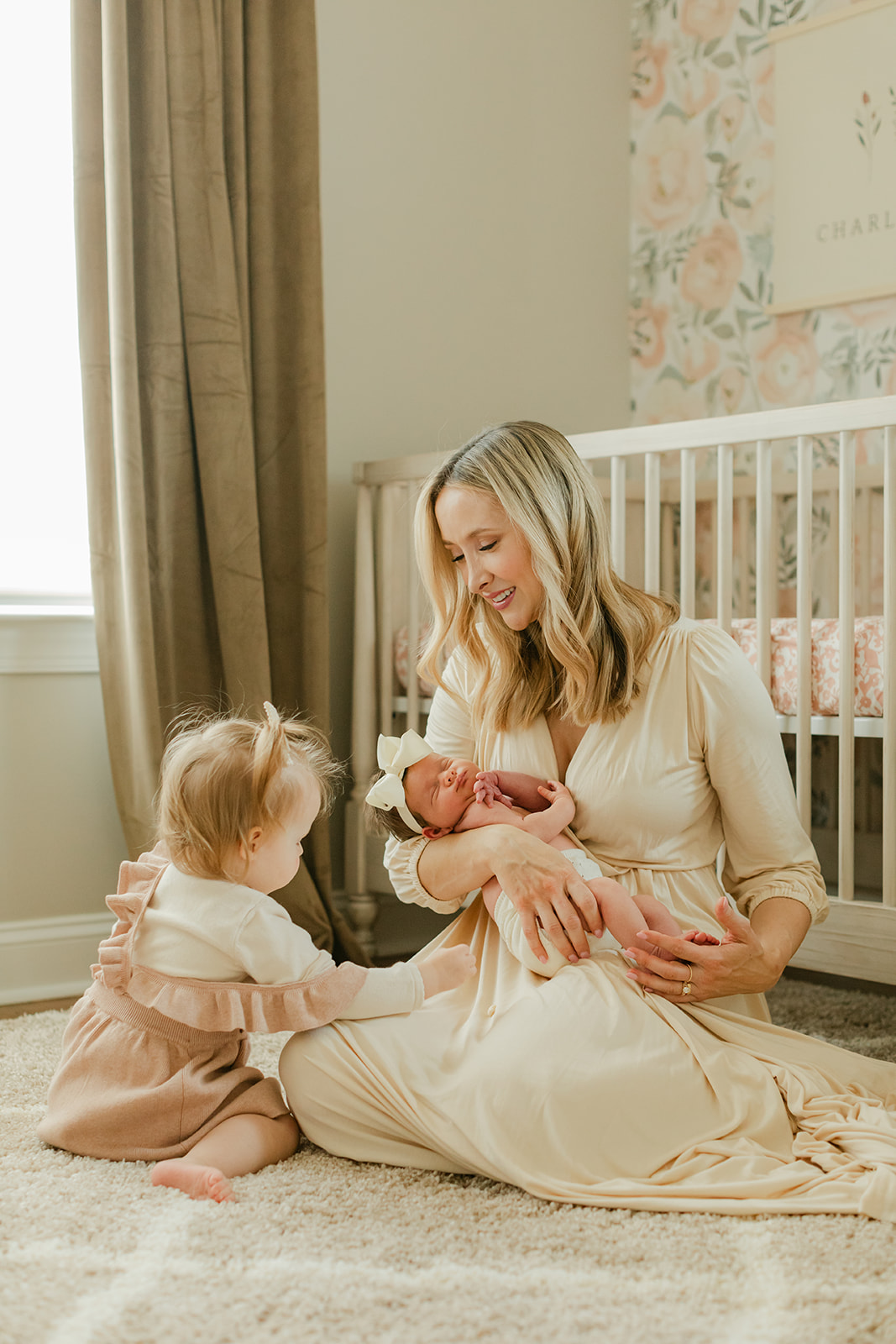 mama with her two daughters. newborn session in nursery