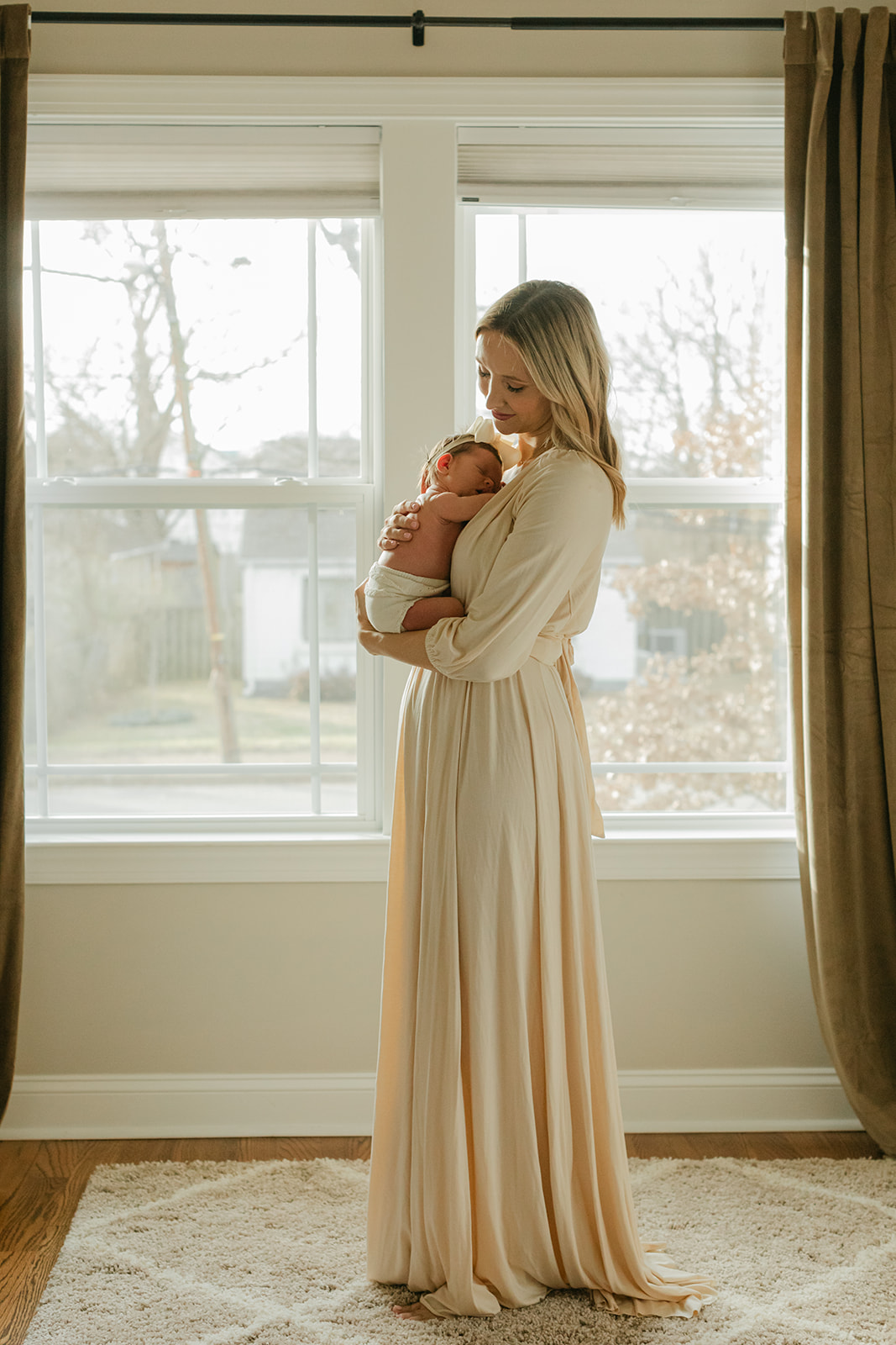 mama in newborn baby girl in nursery