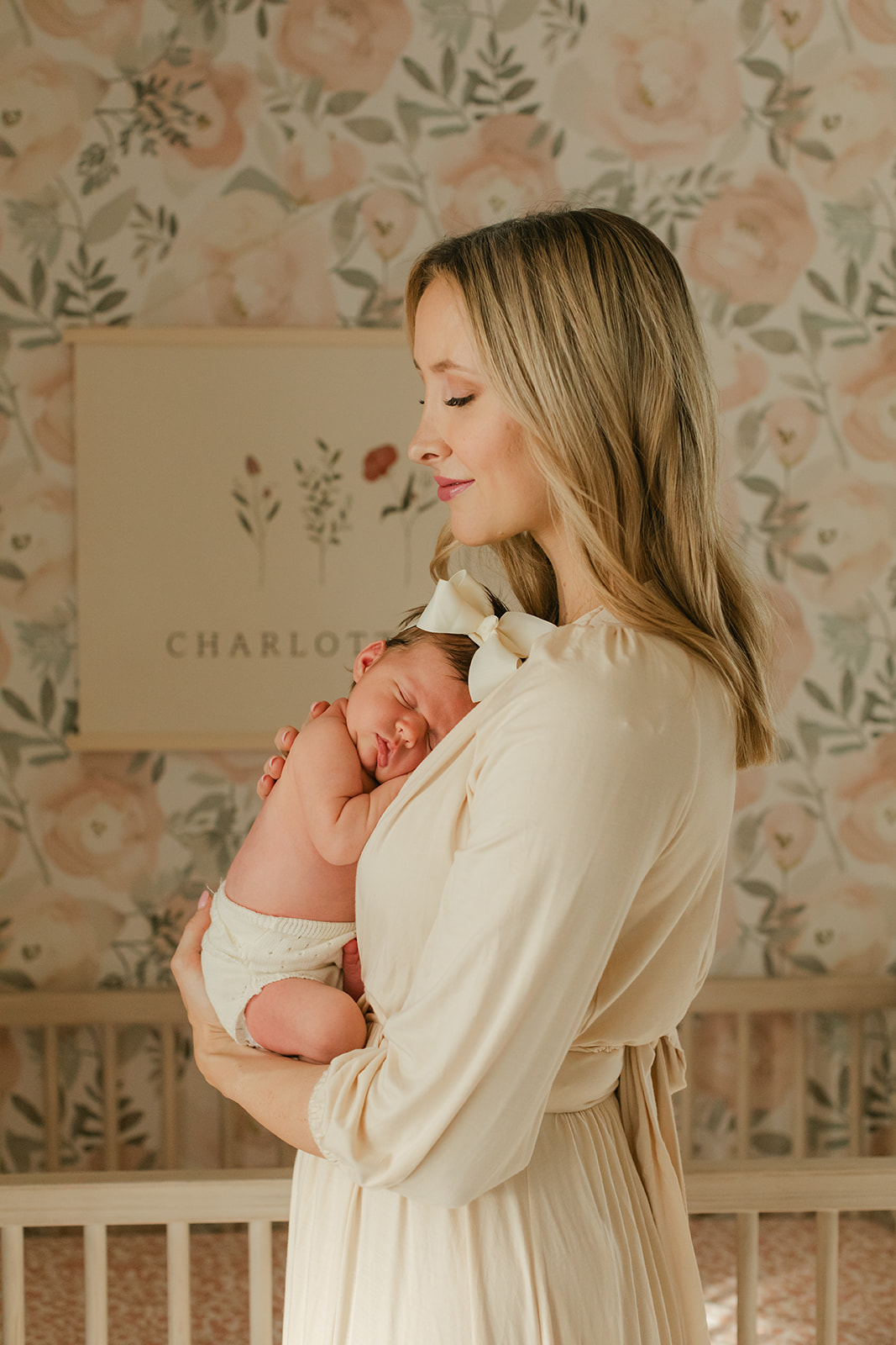 mama in newborn baby girl in nursery