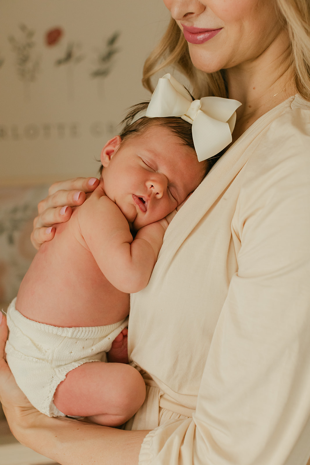 sleepy baby girl on mom's chest. newborn session in nursery